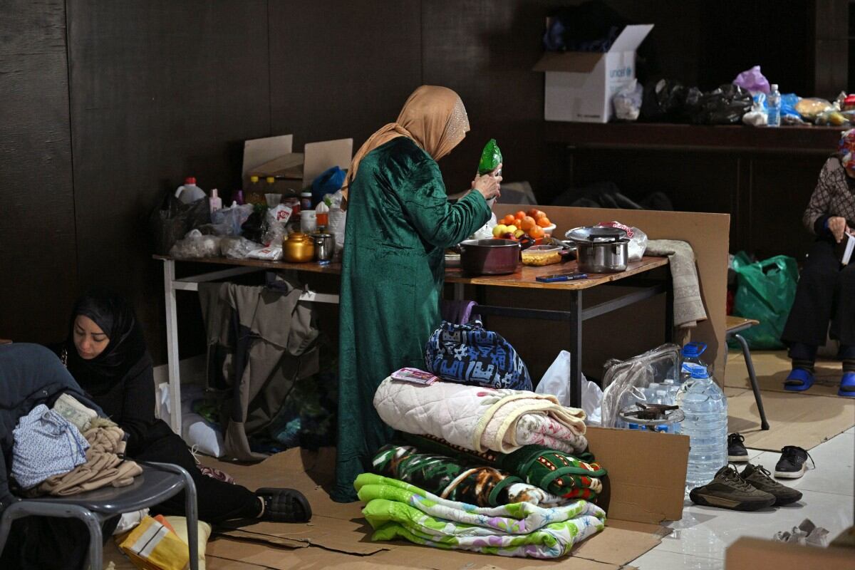 Mujeres preparan comida en una escuela convertida en refugio para personas desplazadas en la localidad de Dekwaneh, al norte de Beirut.