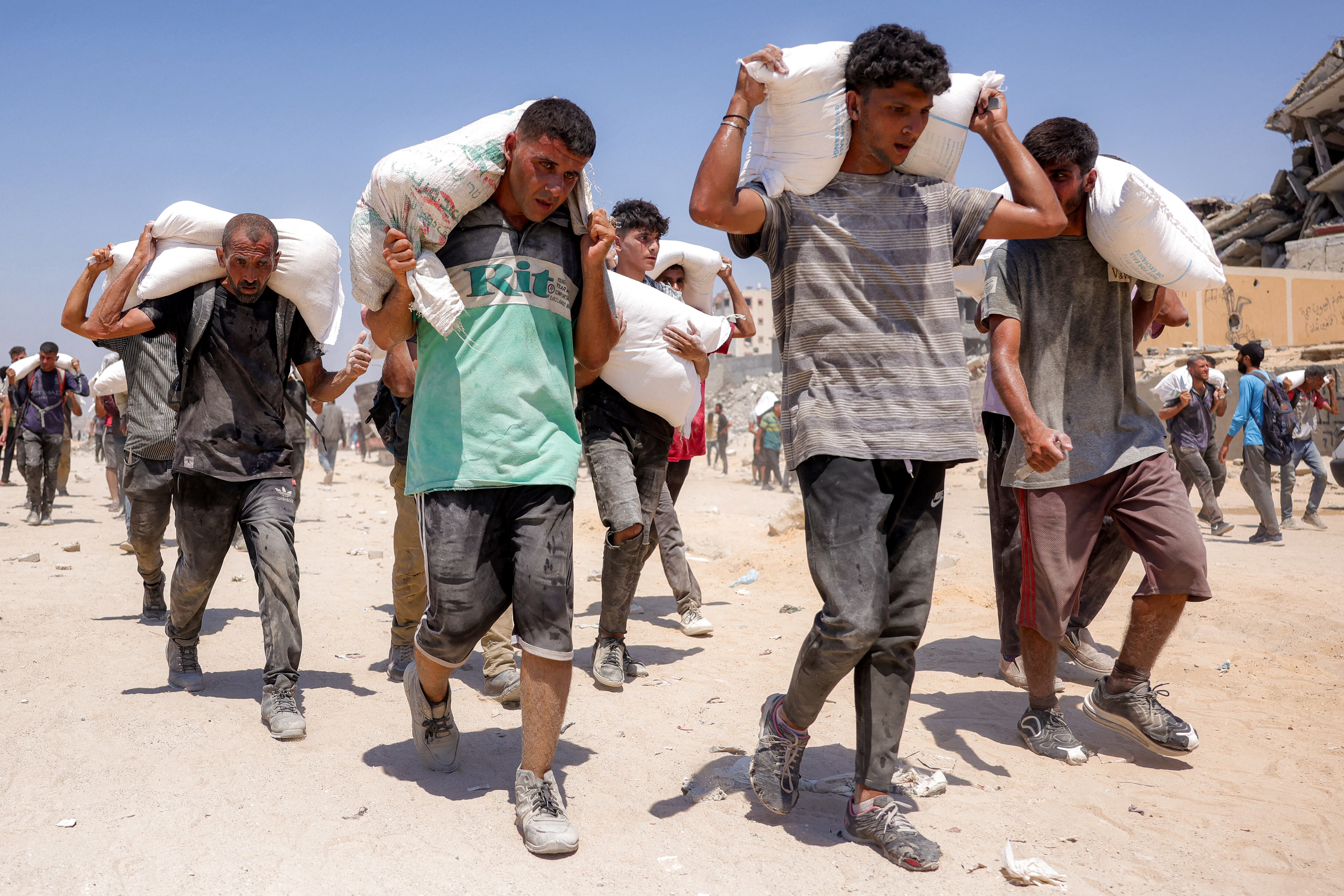 Varias personas caminaban con sacos de harina tras el ingreso de camiones con ayuda humanitaria al norte de Gaza este 27 de julio de 2025, provenientes del paso fronterizo de Zikim.
(Foto: Bashar Taleb / AFP)