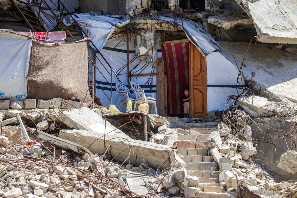 Un niño observa desde la entrada de un refugio entre los escombros de un edificio gravemente dañado en Jan Yunis, en el sur de la Franja de Gaza, el 25 de agosto de 2026.
