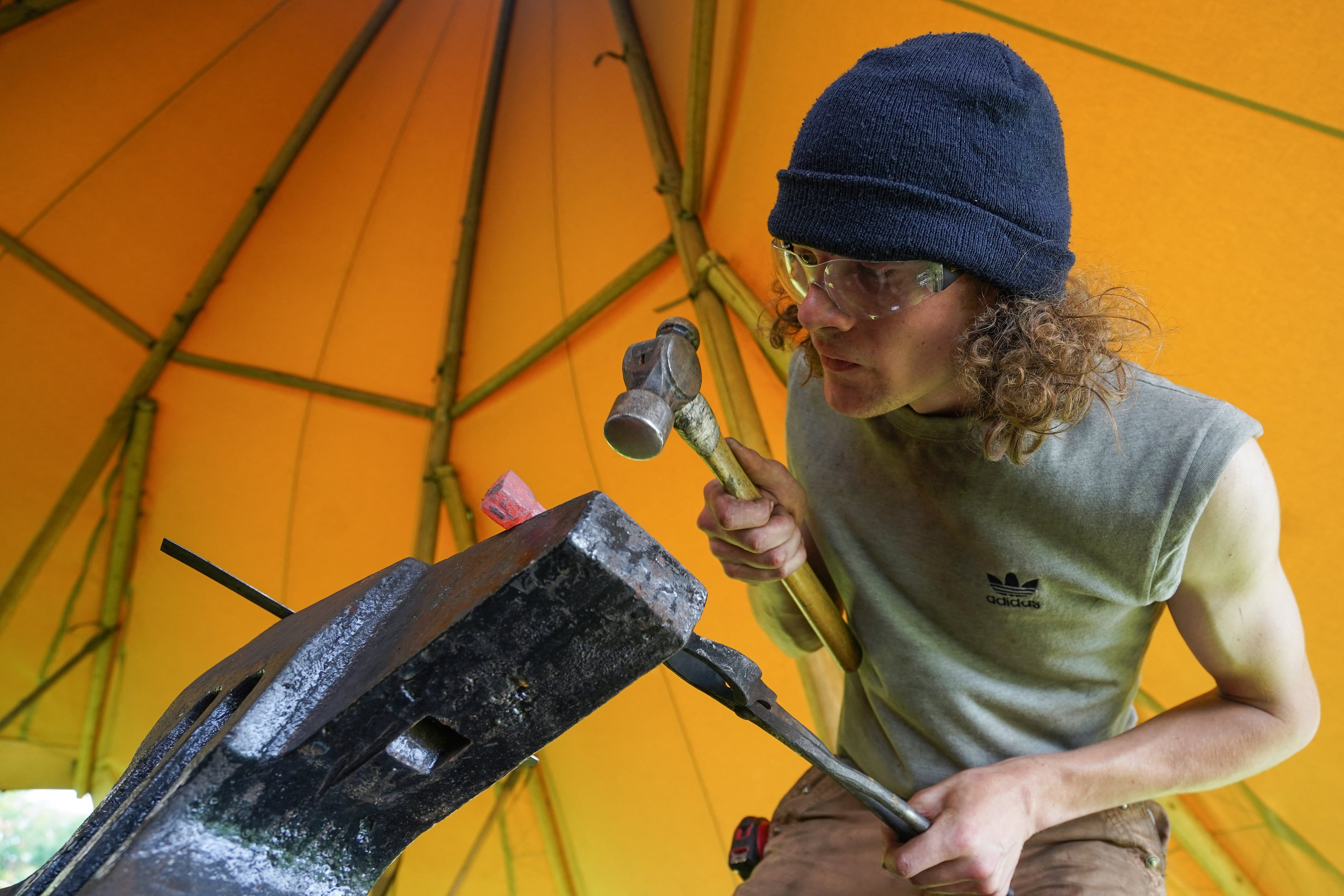 Un estudiante de la Escuela Nacional de Herrería de Gran Bretaña martilla hierro contra un yunque cerca del Museo de Barcos Vikingos en Roskilde, Dinamarca. Fotografía: