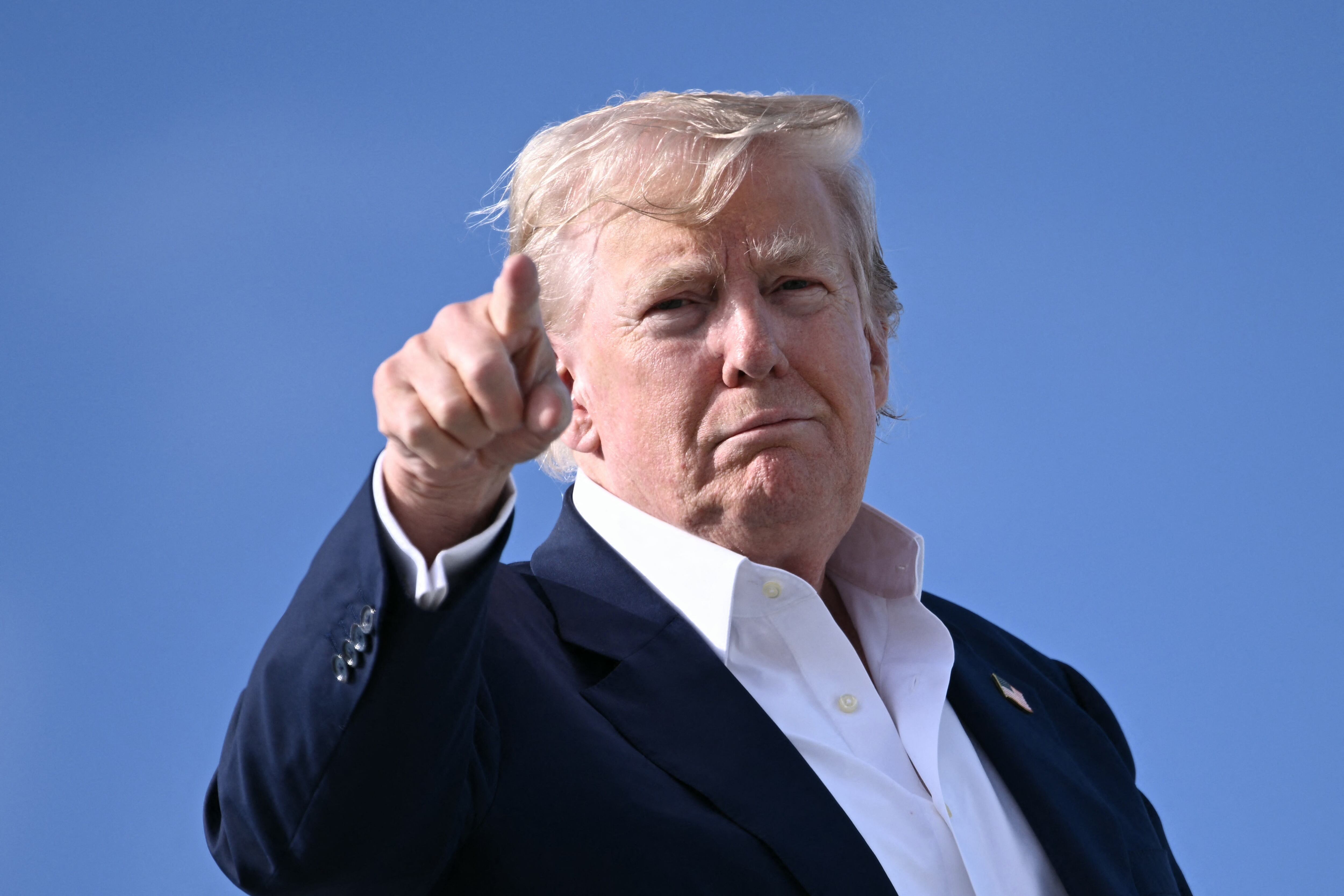 US President Donald Trump points as he boards Air Force One at RAF Lossiemouth, north-east Scotland on July 29, 2025 at the end of his trip to Scotland. (Photo by Brendan SMIALOWSKI / AFP)