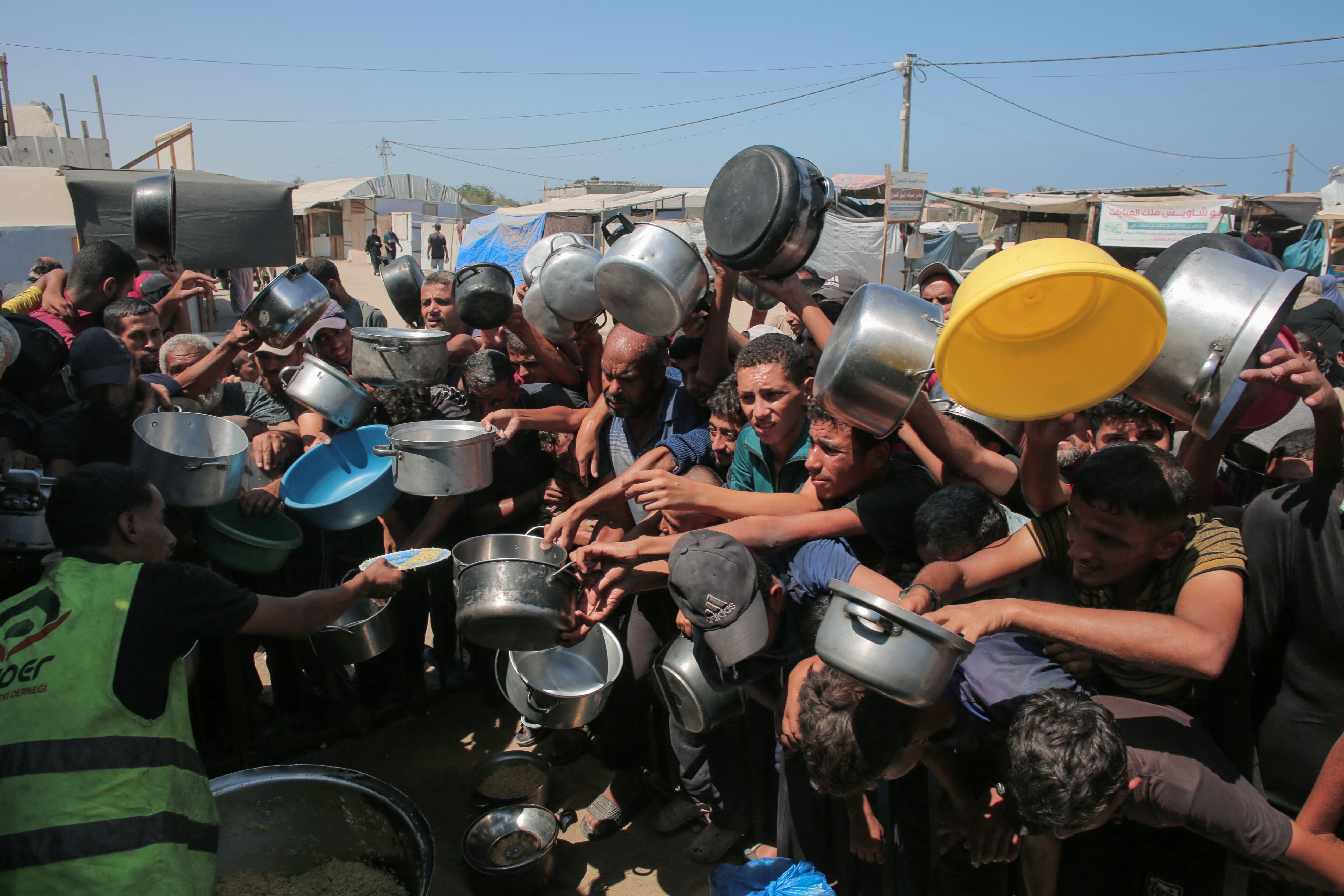 Palestinos se apresuran a recibir raciones de comida de un comedor social en Khan Yunis, al sur de la Franja de Gaza, este 27 de agosto. Fotografía: