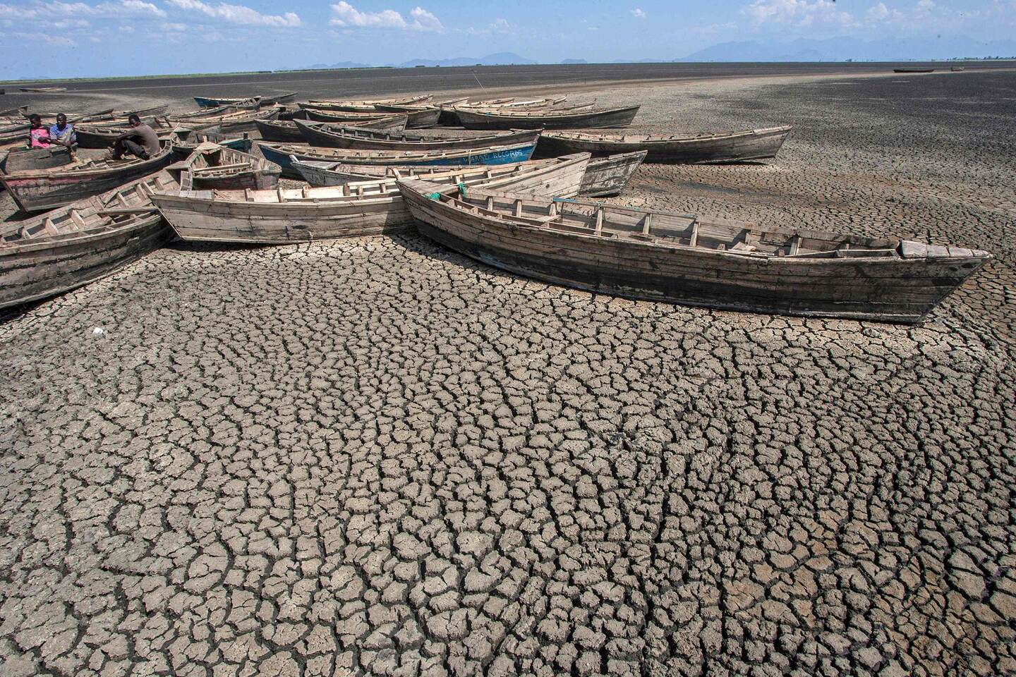 (FILES) In this file photo taken on October 18, 2018 young men sit in stationary engineless boats which lie idle at the dried inland Lake Chilwa's Chisi Island harbour in Zomba District, eastern Malawi. - Rising global temperature, rising sea levels, intensification of extreme events... The publication of the report of the Intergovernmental Panel on Climate Change (IPCC) is scheduled on August 9. (Photo by AMOS GUMULIRA / AFP)