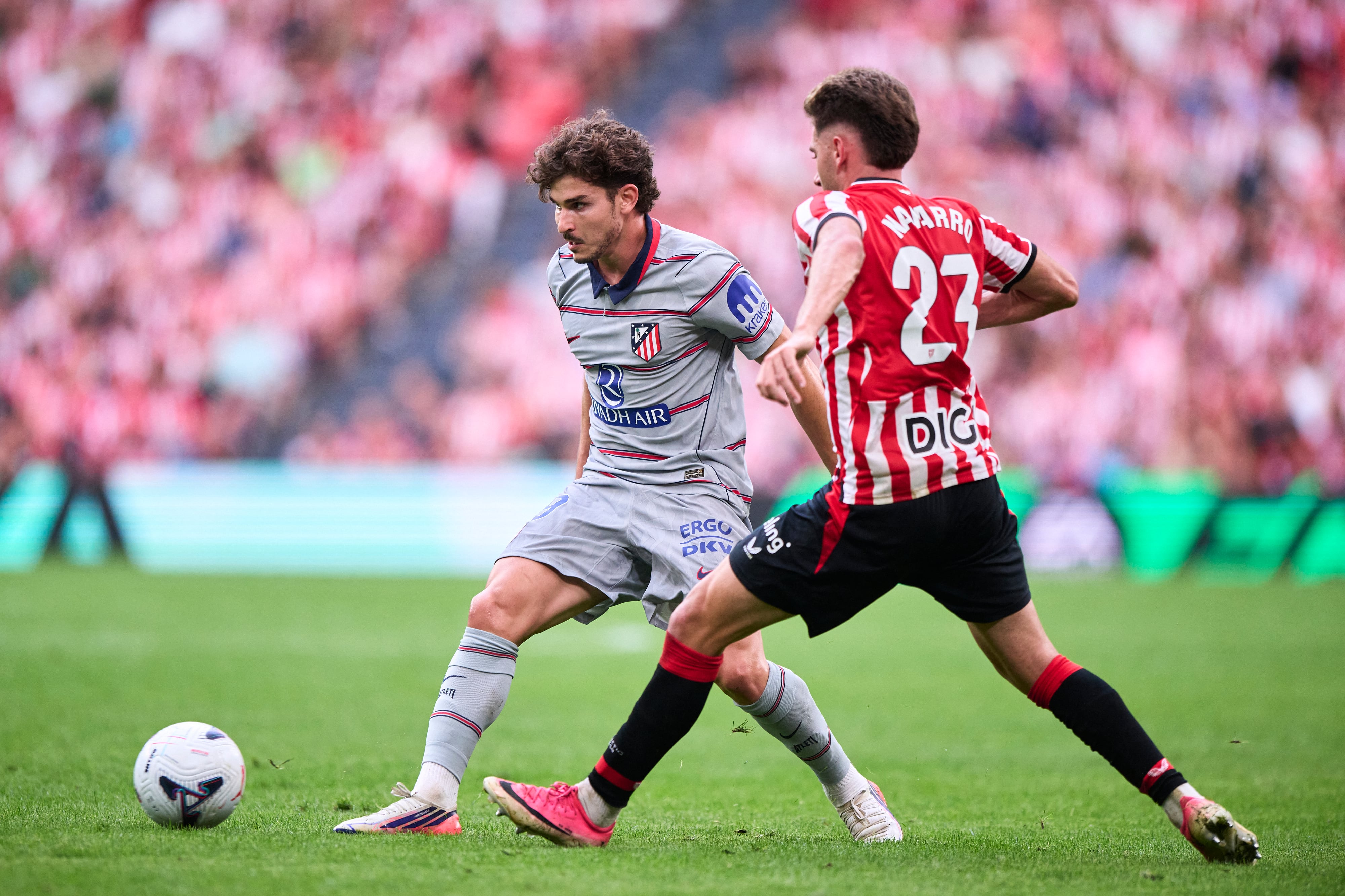 Julian Álvarez, del Atlético de Madri, trata de superar a Robert Navarro, del Athletic de Bilbao, en este compromiso por la Liga Española en el Estadio San Mamés.