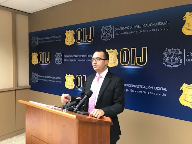 Gerald Campos, subdirector del Organismo de Investigación Judicial (OIJ) en 2018, hablando en una conferencia de prensa frente al logo institucional.