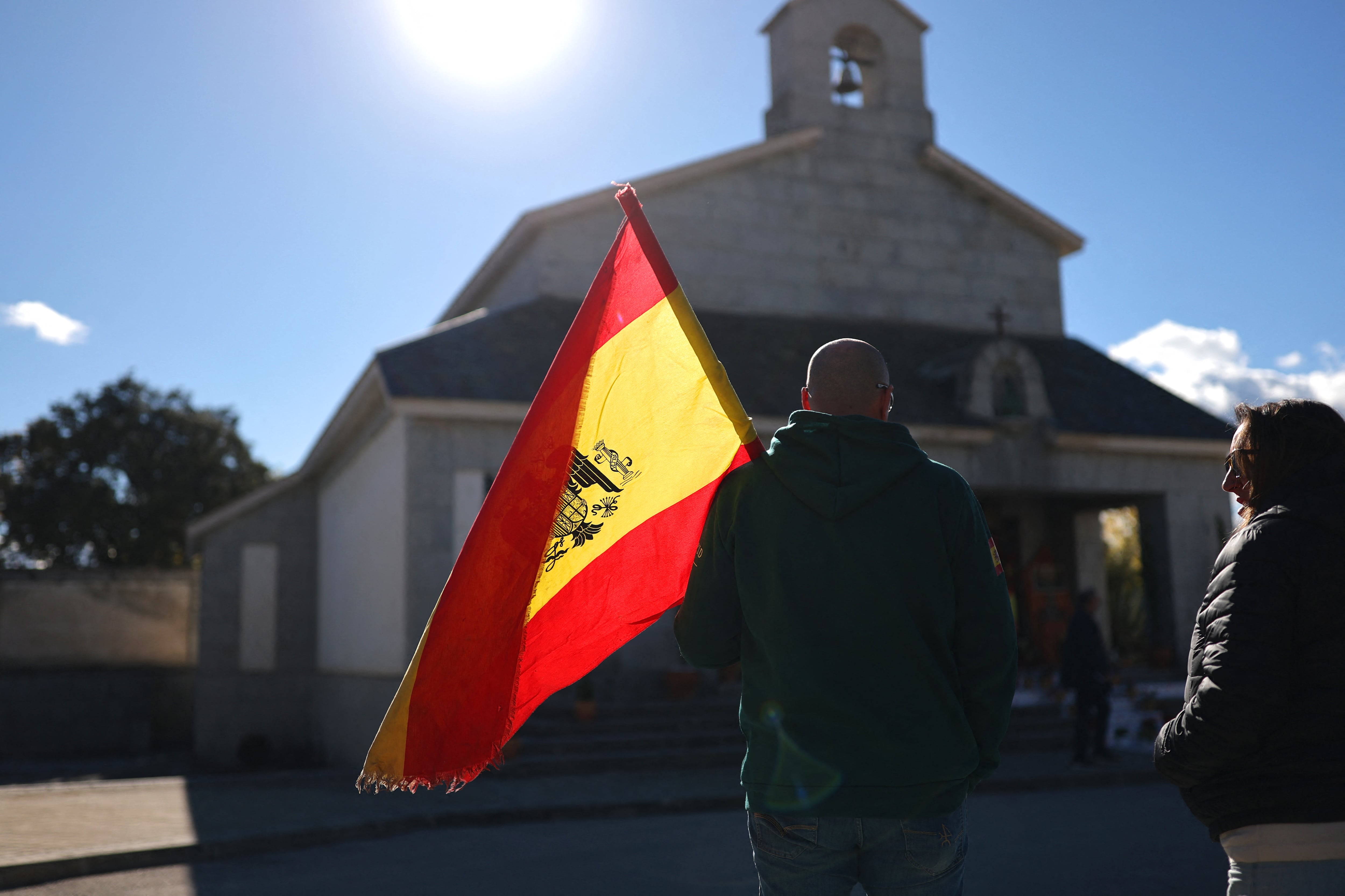 Un partidario de Franco sostiene una bandera franquista preconstitucional mientras rinde homenaje al dictador español Francisco Franco, 50 años después de su muerte, frente a su tumba en el cementerio de Mingorrubio en El Pardo, al norte de Madrid, el 20 de noviembre de 2025. Tras su exhumación en el Valle de Cuelgamuros en 2019, los restos de Franco fueron enterrados en El Pardo junto a los de su esposa Carmen Polo, atrayendo visitas anuales de quienes añoran su régimen. El gobierno izquierdista de España anunció el 19 de noviembre de 2025 480 nuevos eventos que se celebrarán este año para conmemorar el 50 aniversario de la muerte del dictador de derecha Francisco Franco y la restauración de la democracia. Franco murió el 20 de noviembre de 1975, a los 82 años, después de gobernar España con puño de hierro durante casi cuatro décadas.