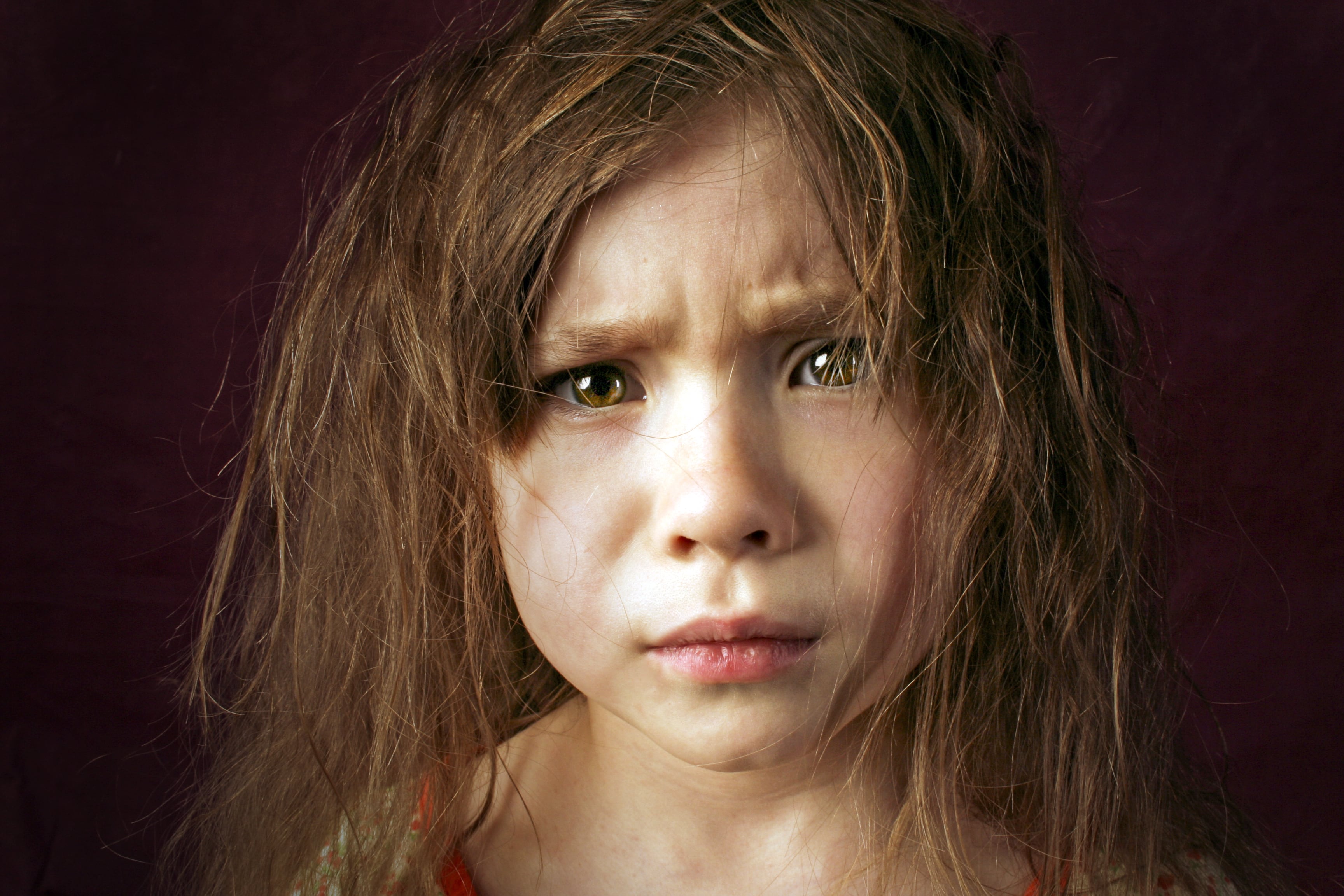 Niña despeinada y triste, enojada, dolida, a punto de llorar, a punto de romper en llanto