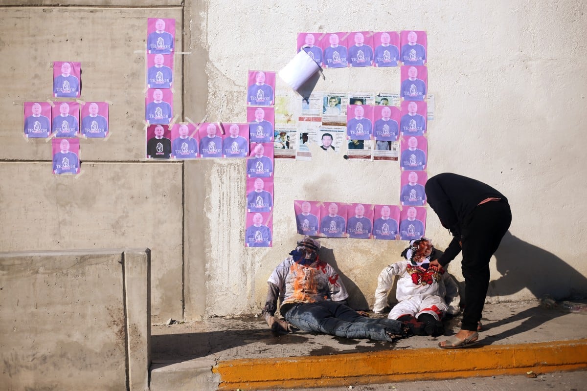 Un manifestante prende fuego a efigies de autoridades locales durante una manifestación para conmemorar el 12.º aniversario de la desaparición de los 43 estudiantes de Ayotzinapa, frente al Palacio de Justicia de Iguala, en el estado de Guerrero, México, el 27 de septiembre de 2026.
