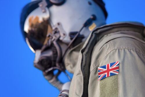 Piloto de la Fuerza Aérea británica con casco y uniforme, mostrando la bandera del Reino Unido en su brazo.