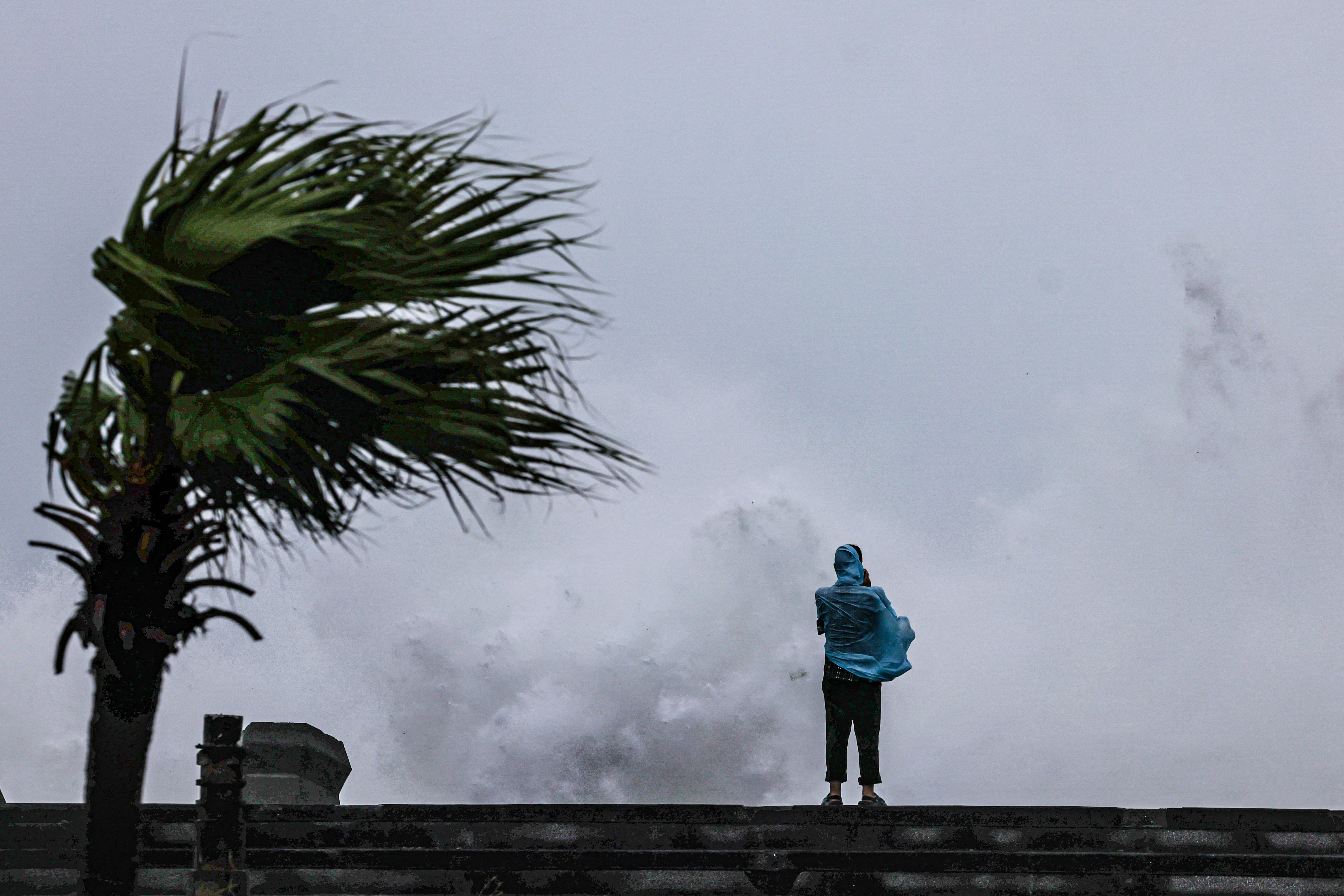 Una persona observa las grandes olas que golpean la costa de Keelung, en el noreste de Taiwán, mientras el tifón Bavi se desplazaba cerca de la isla el 11 de julio de 2026.