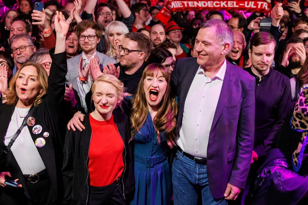 Los principales candidatos del partido de izquierda Die Linke, Heidi Reichinnek y Jan van Aken, junto a la copresidenta Ines Schwerdtner, reaccionan con miembros del partido durante la noche electoral en Berlín