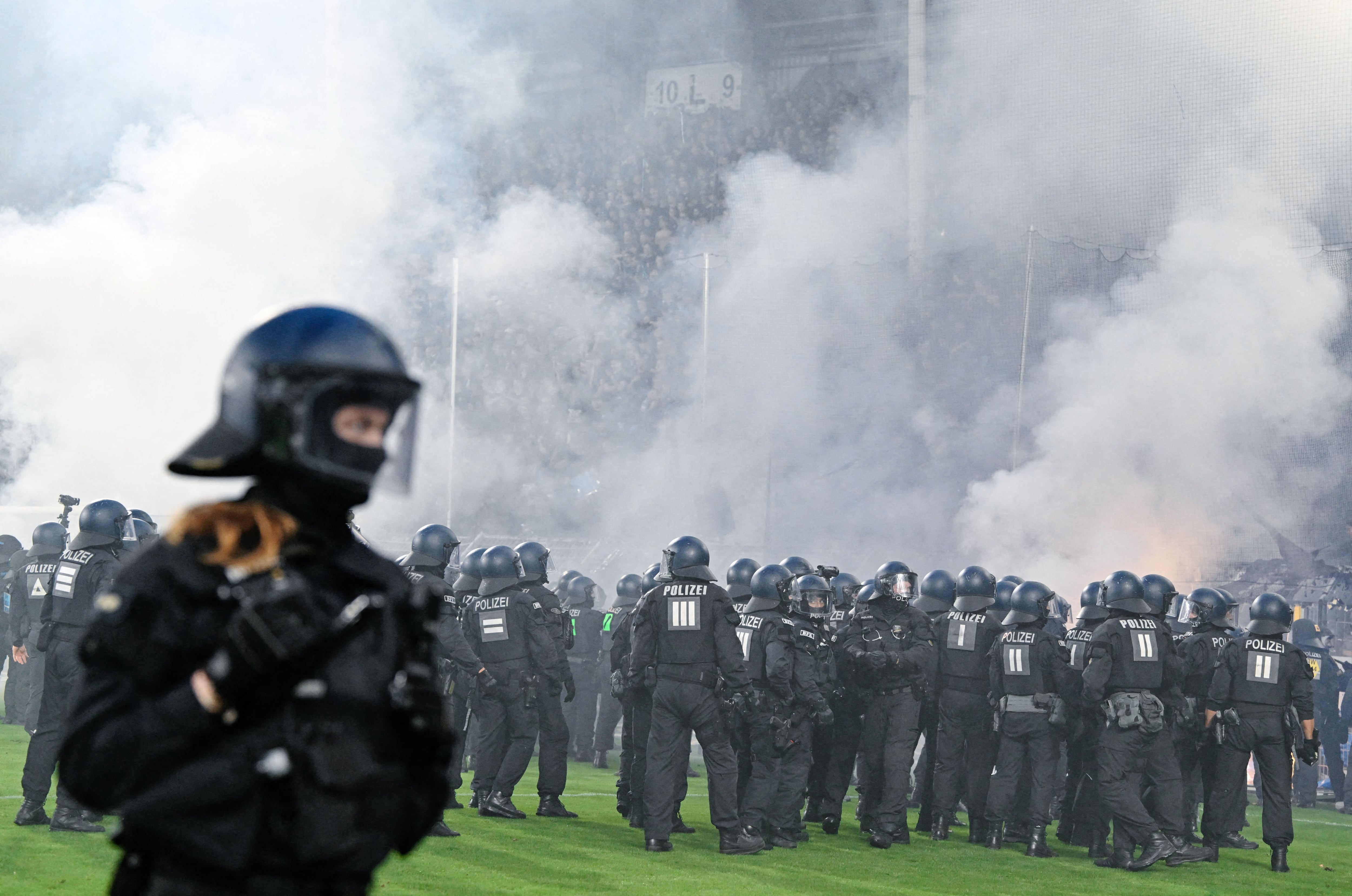La policía interviene ante los aficionados del Waldhof Mannheim, durante los serios incidentes en el partido ante el Kaiserslautern por la Copa de Alemania.