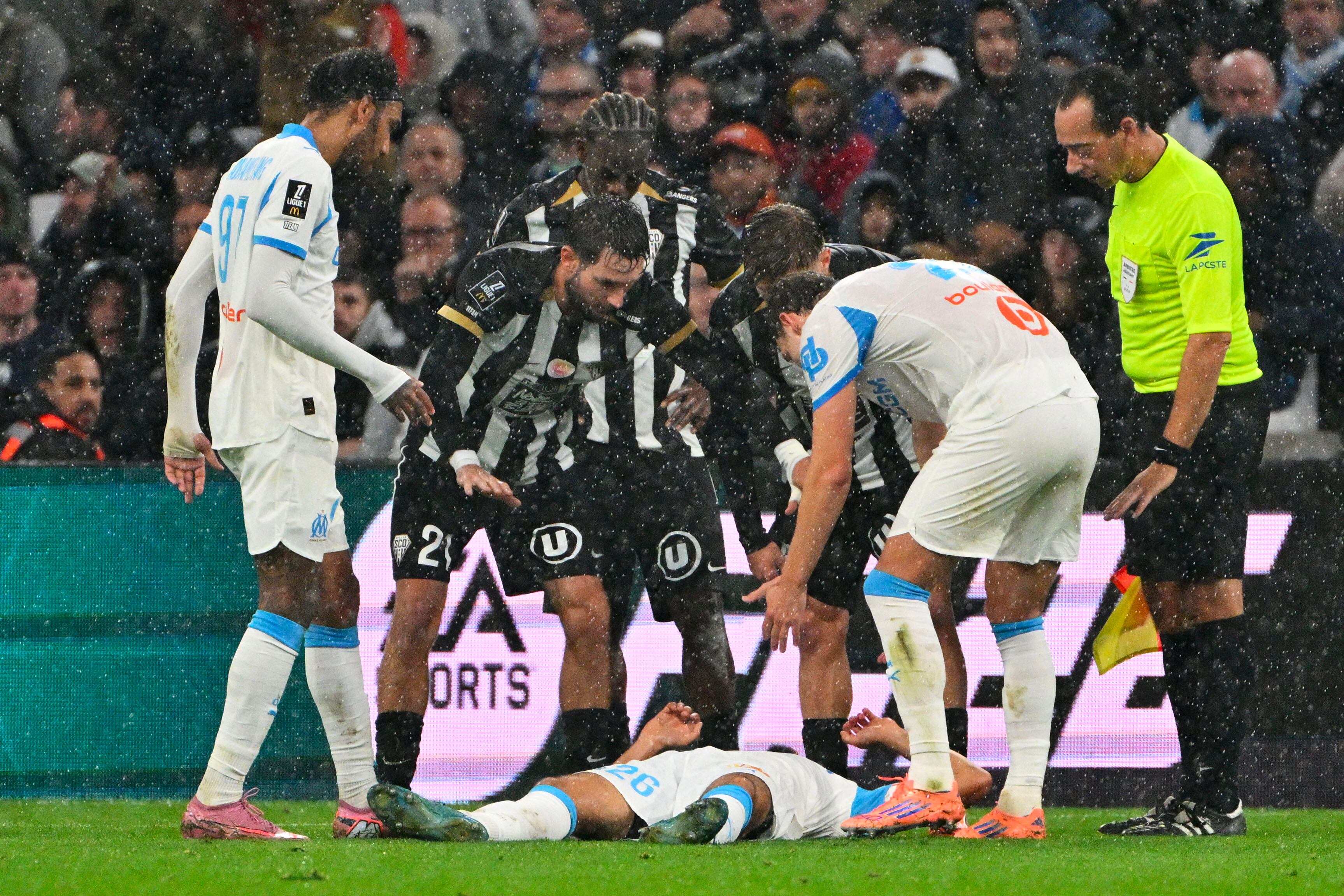 El mediocampista francés del Marsella, número 26, Bilal Nadir, fue rodeado por jugadores del Angers y del Marsella tras colapsar durante el partido de la Ligue 1 francesa entre el Olympique de Marsella (OM) y el SCO Angers, disputado en el estadio Vélodrome, en Marsella, al sur de Francia, el 29 de octubre de 2025.
(Foto: Christophe SIMON / AFP)