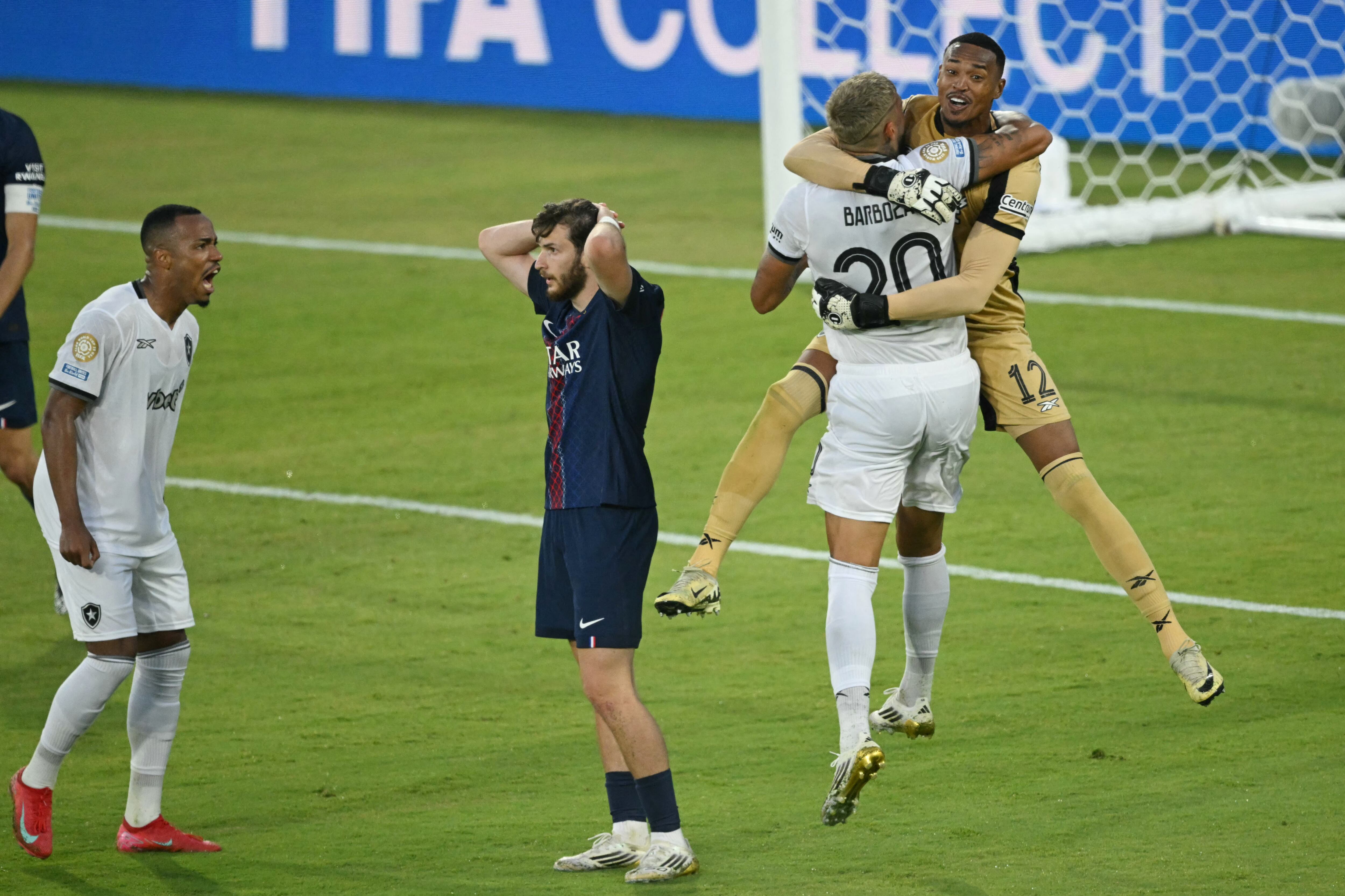 El arquero de Botafogo John y su compañero Alexander Barboza se funden en un abrazo mientras Khvicha Kvaratskhelia se toma la cabeza luego de la derrota del PSG.