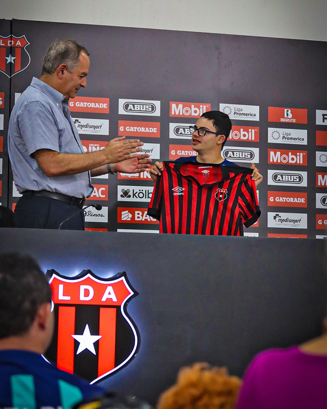 Joseph Joseph le entregó la camisa de Liga Deportiva Alajuelense a Ariel Guzmán, jugador del LDA Team Down.