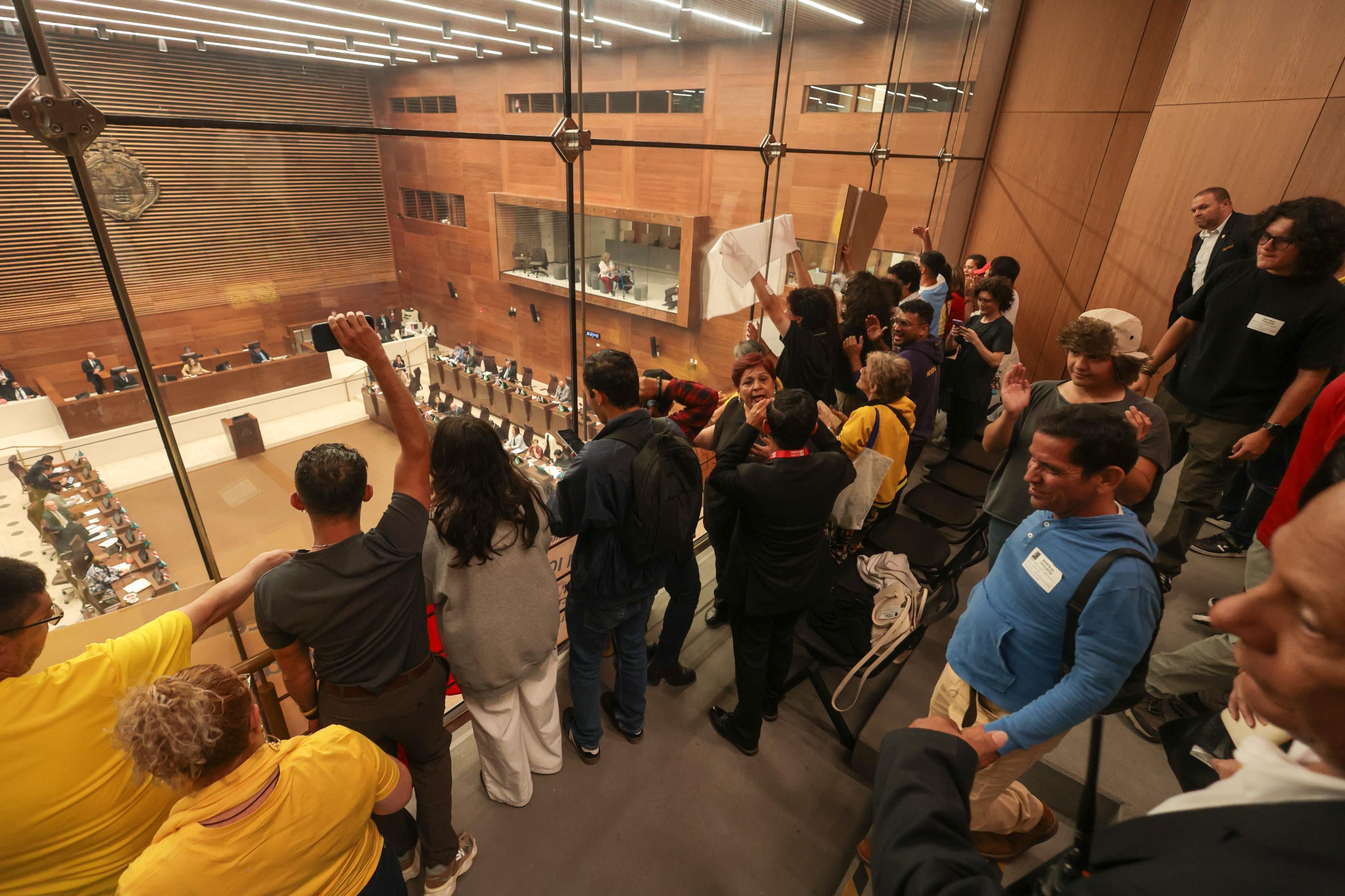 Un grupo de manifestantes que se oponen al proyecto de armonización eléctrica se concentran en la barra del público en la Asamblea Legislativa el 26 de mayo de 2026.