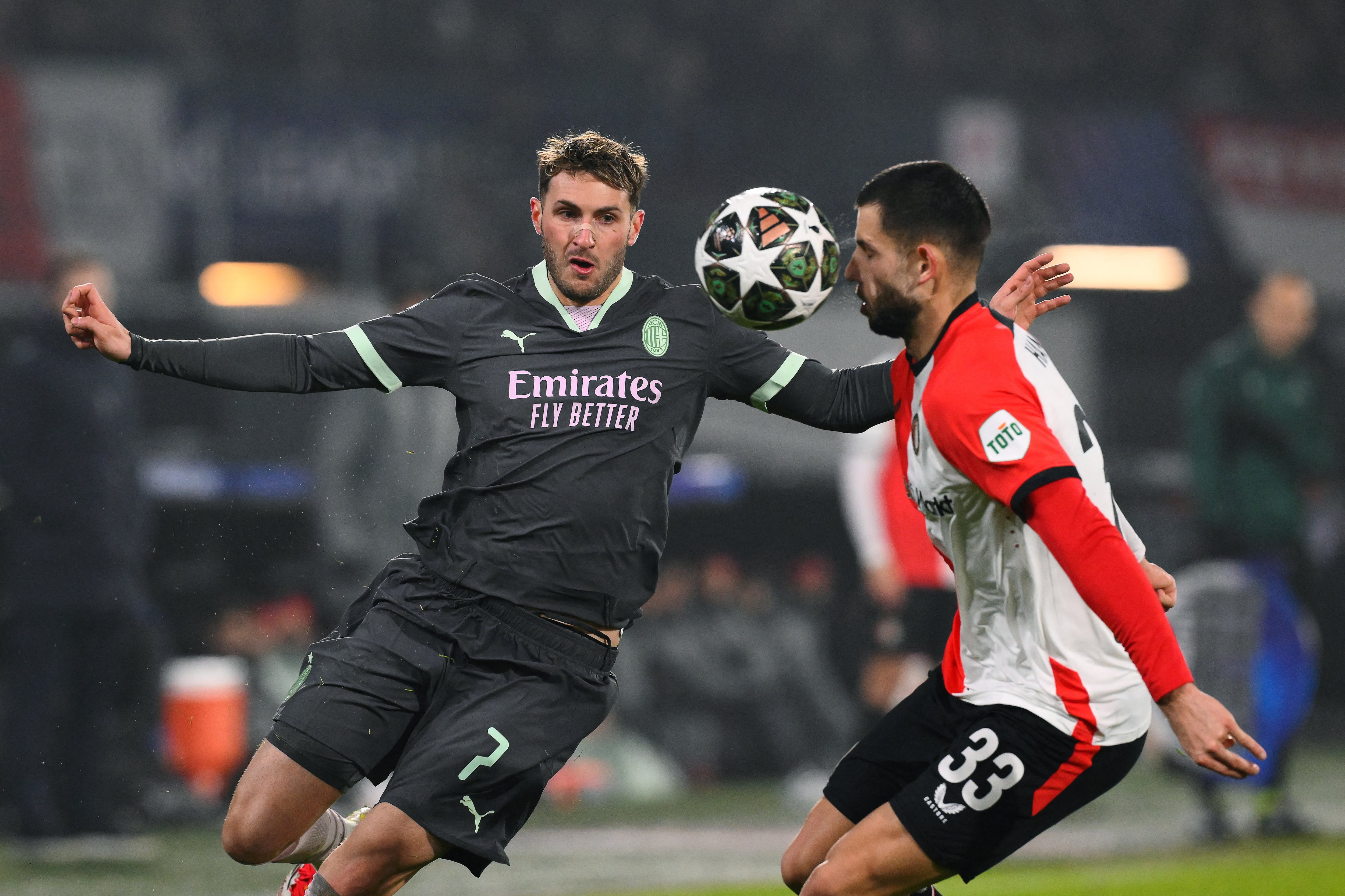 AC Milan's Mexican forward #07 Santiago Gimenez (L) fights for the ball with Feyenoord's Slovakian defender #33 David Hancko during the UEFA Champions League knockout phase play-off 1st leg football match between Feyenoord Rotterdam and AC Milan at the Stadion Feijenoord "De Kuip" in Rotterdam, on February 12, 2025. (Photo by JOHN THYS / AFP).