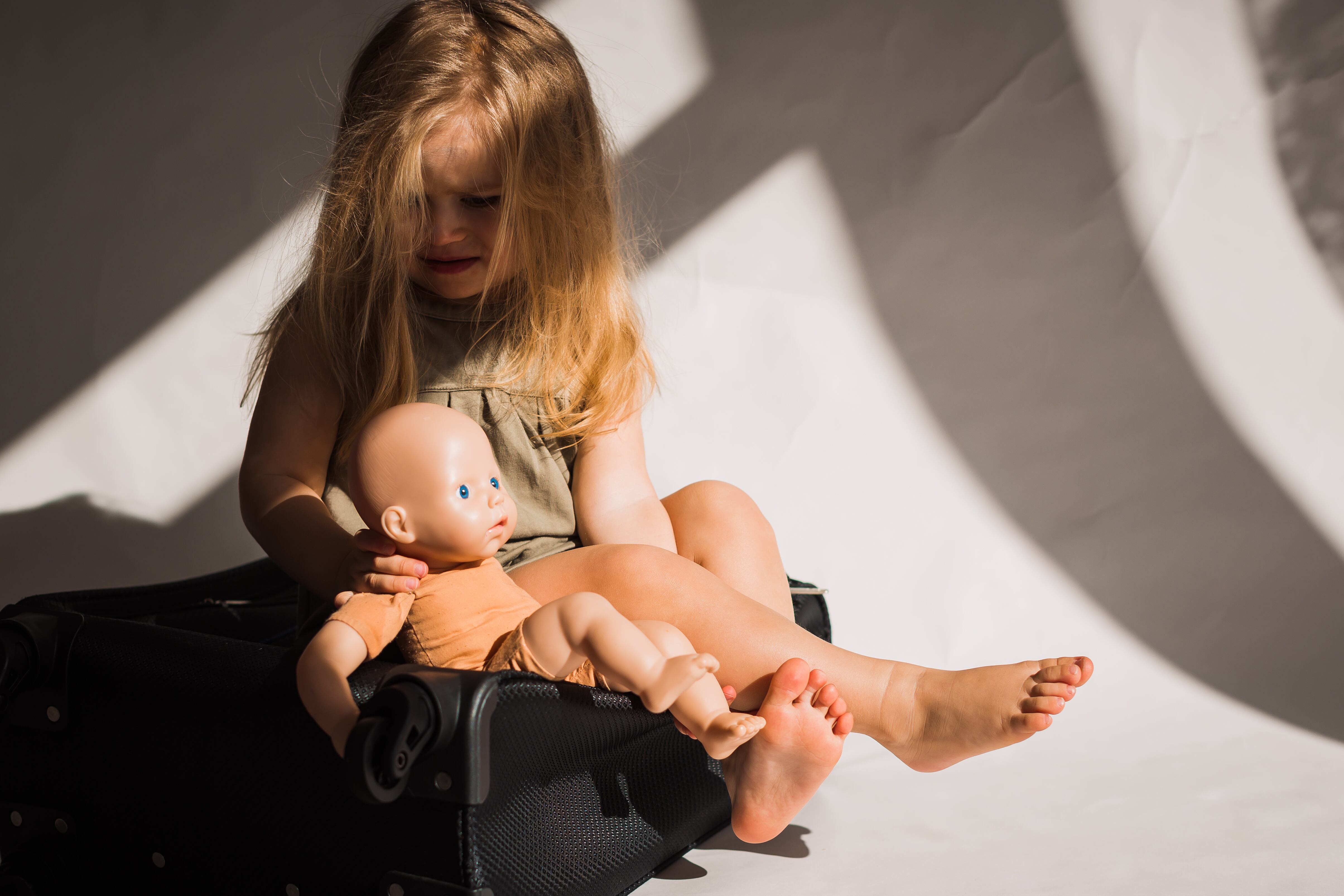 Niña triste, llorando, con muñeco