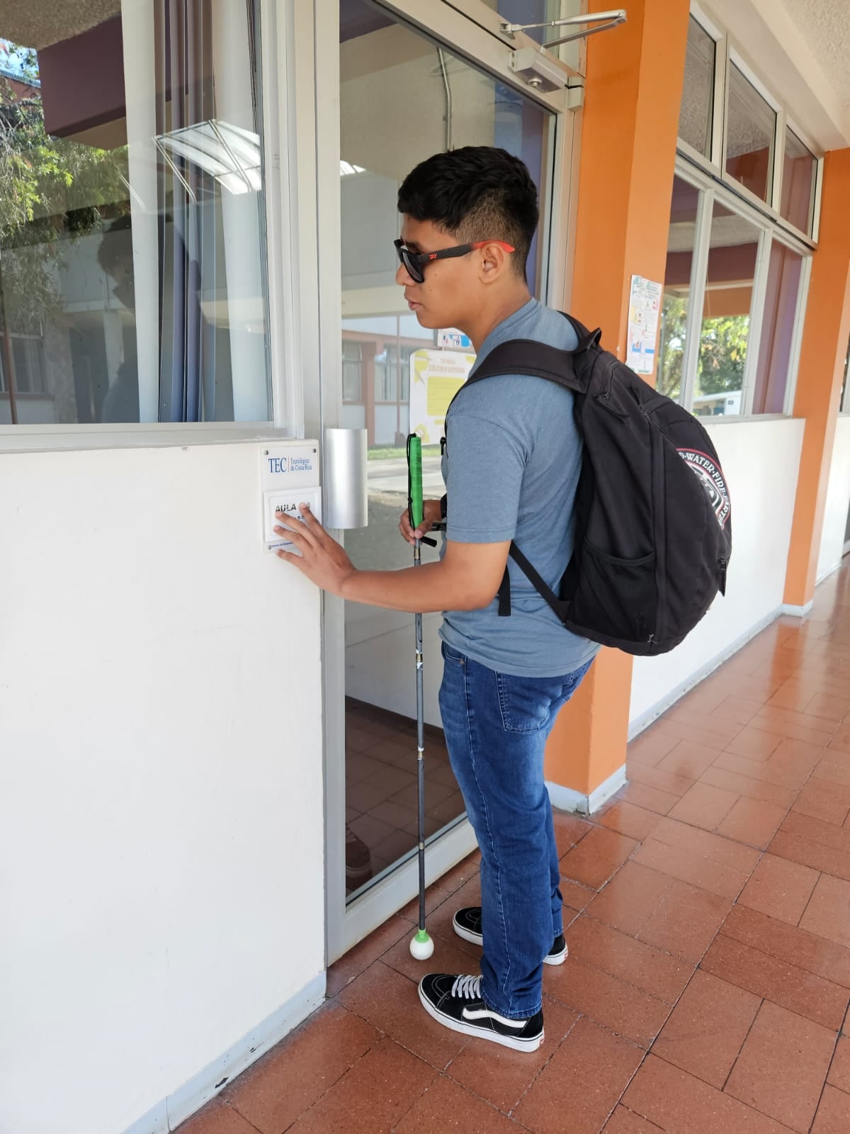 Justin mientras lee un rótulo en braille, antes de ingresar a un aula del TEC.