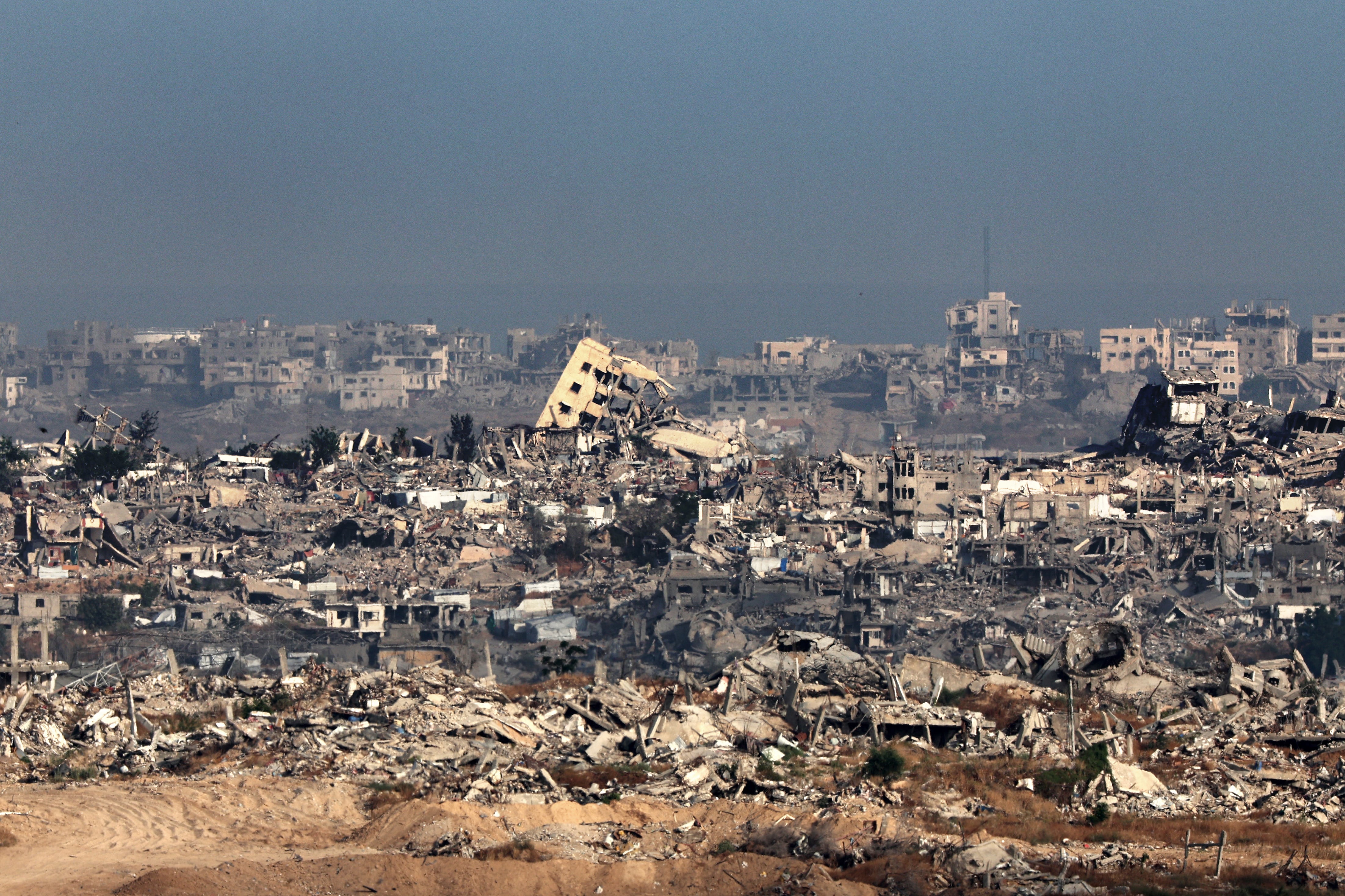 Esta imagen, tomada desde el sur de Israel, muestra edificios destruidos en la Franja de Gaza este martes, en medio de la guerra en curso contra el movimiento militante palestino Hamás. Fotografía: