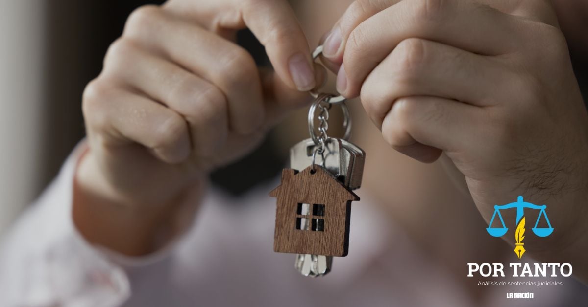 en la imagen, dos manos sosteniendo una llave con un llavero en forma de casa