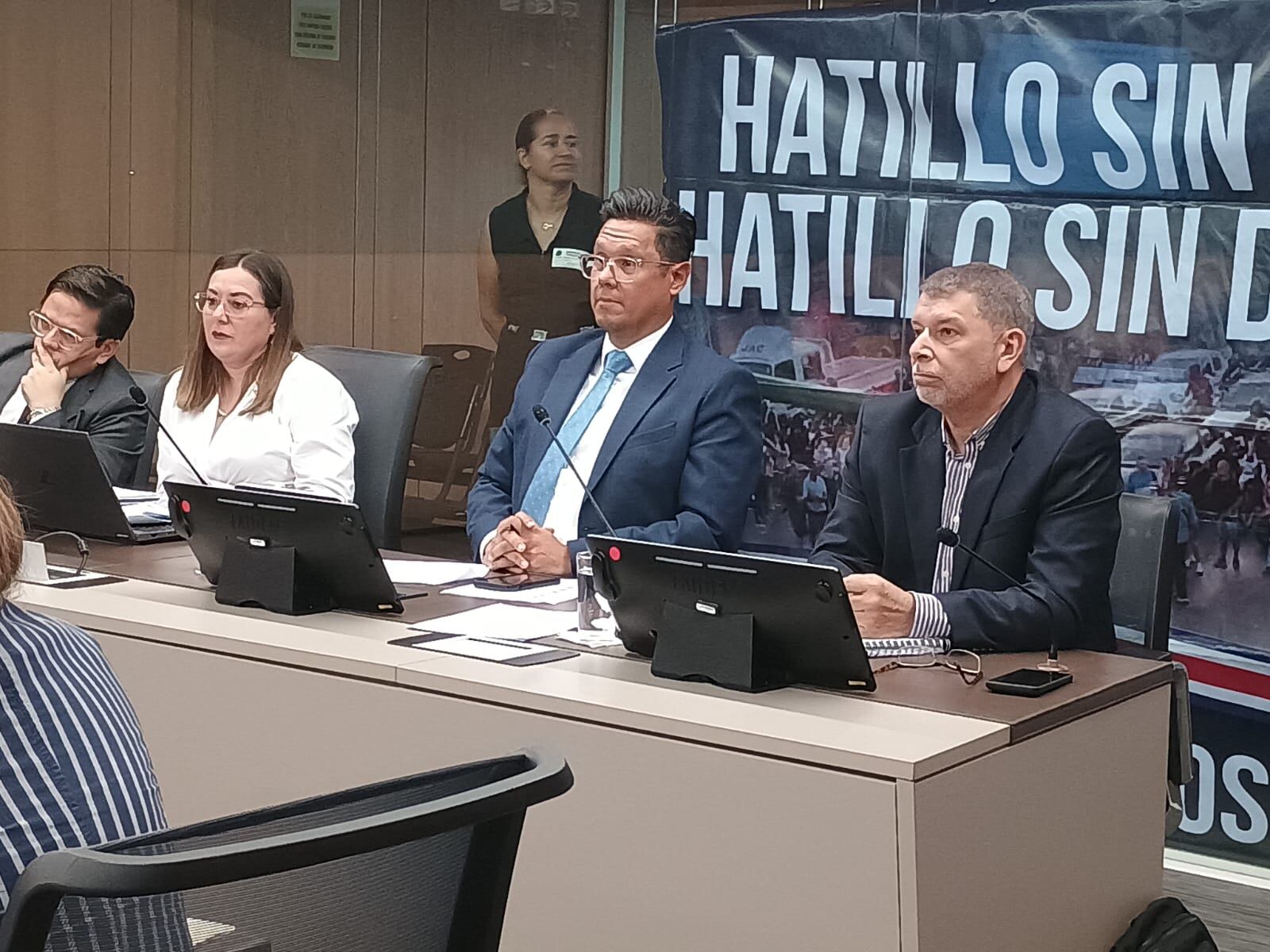 Juan Manuel Quesada Espinoza, presidente del AyA, (al centro con corbata) en la sesión de este 8 de agosto en la Asamblea Legislativa. Vecinos de comunidades afectadas por la falta de agua llegaron con pancartas. Fotografía: Cortesía Asamblea Legislativa.
