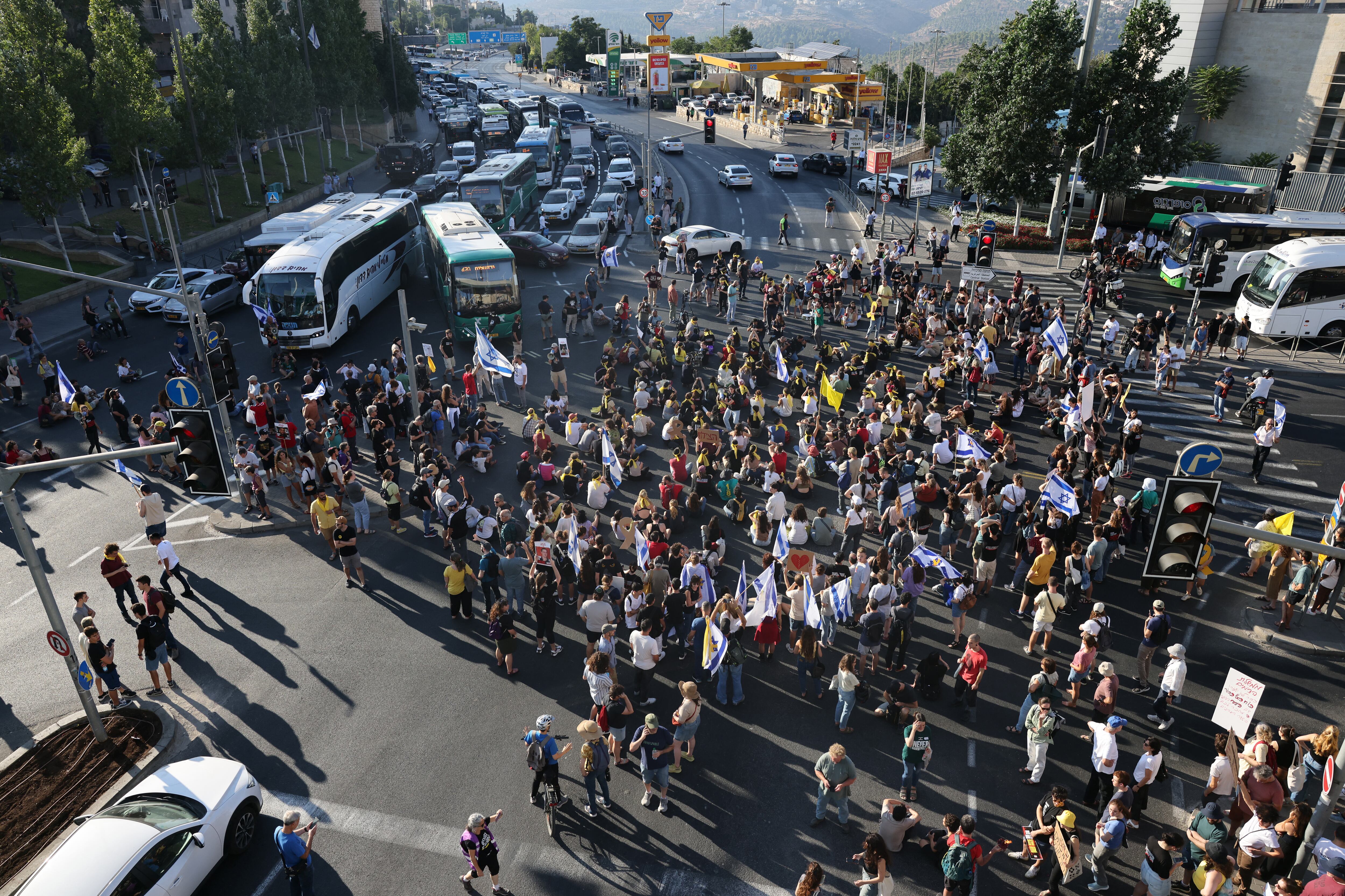 Familiares y simpatizantes de los rehenes israelíes tomados cautivos en la Franja de Gaza desde los ataques del 7 de octubre por militantes palestinos de Hamás bloquean una carretera principal mientras protestan en el centro de Jerusalén.