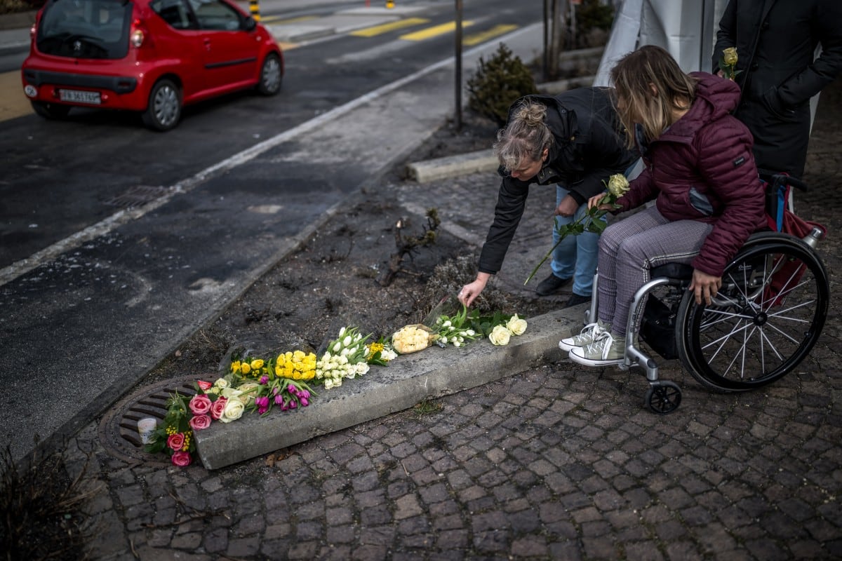 Dos mujeres depositan flores el 11 de marzo de 2026 en Kerzers, en el oeste de Suiza, donde un autobús se incendió el 10 de marzo, causando al menos seis muertos y cinco heridos en lo que la policía indicó que podría haber sido un acto deliberado.