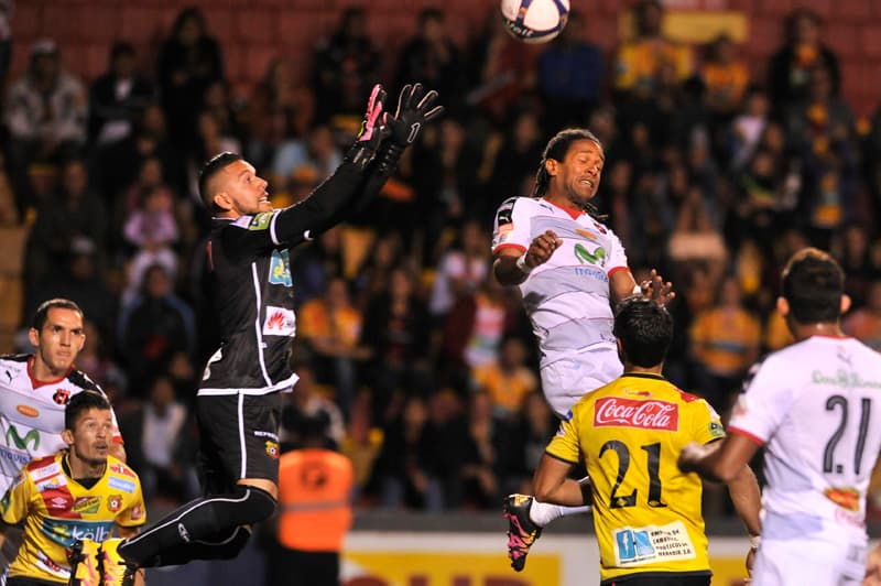 El arquero Leonel Moreira (izquierda) le gana un duelo por las alturas al atacante de Alajuelense Jonathan McDonald. | JOSÉ CORDERO