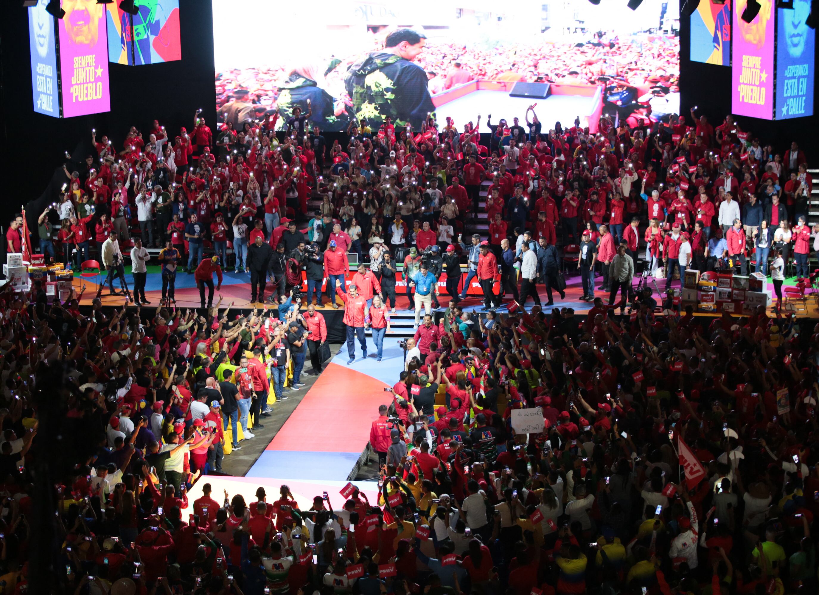 Nicolás Maduro (centro), acompañado por su esposa, Cilia Flores, saludando a sus seguidores a su llegada a un Congreso para anunciar su candidatura con el Partido Socialista Unido de Venezuela (PSUV) en el estadio Poliedro.