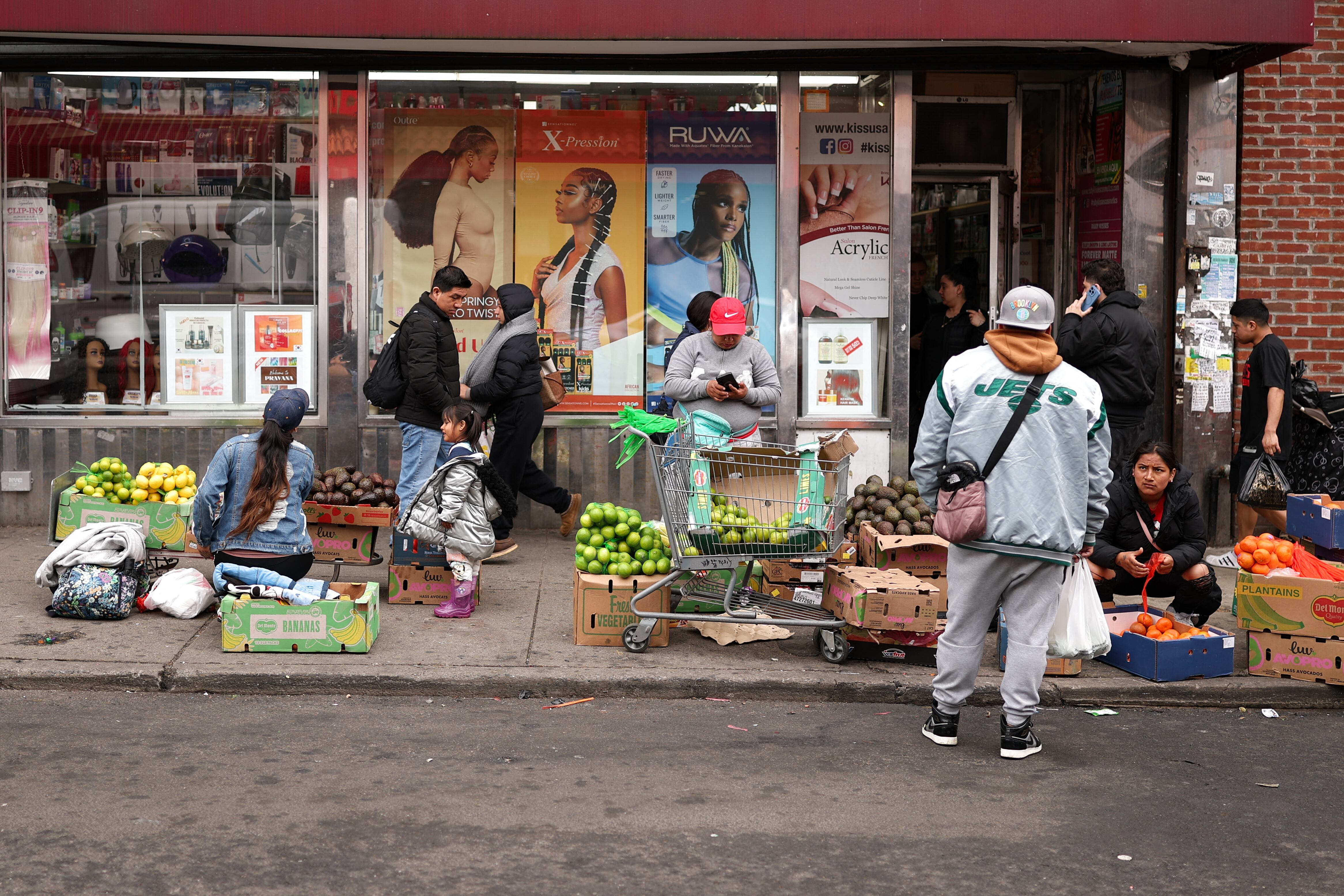People sell fruits and vegetables in a street in the Corona Plaza area of the Queens borough of New York City on March 20, 2025. A local business owner says that the fear caused by President Donald Trump's immigration policies have lef