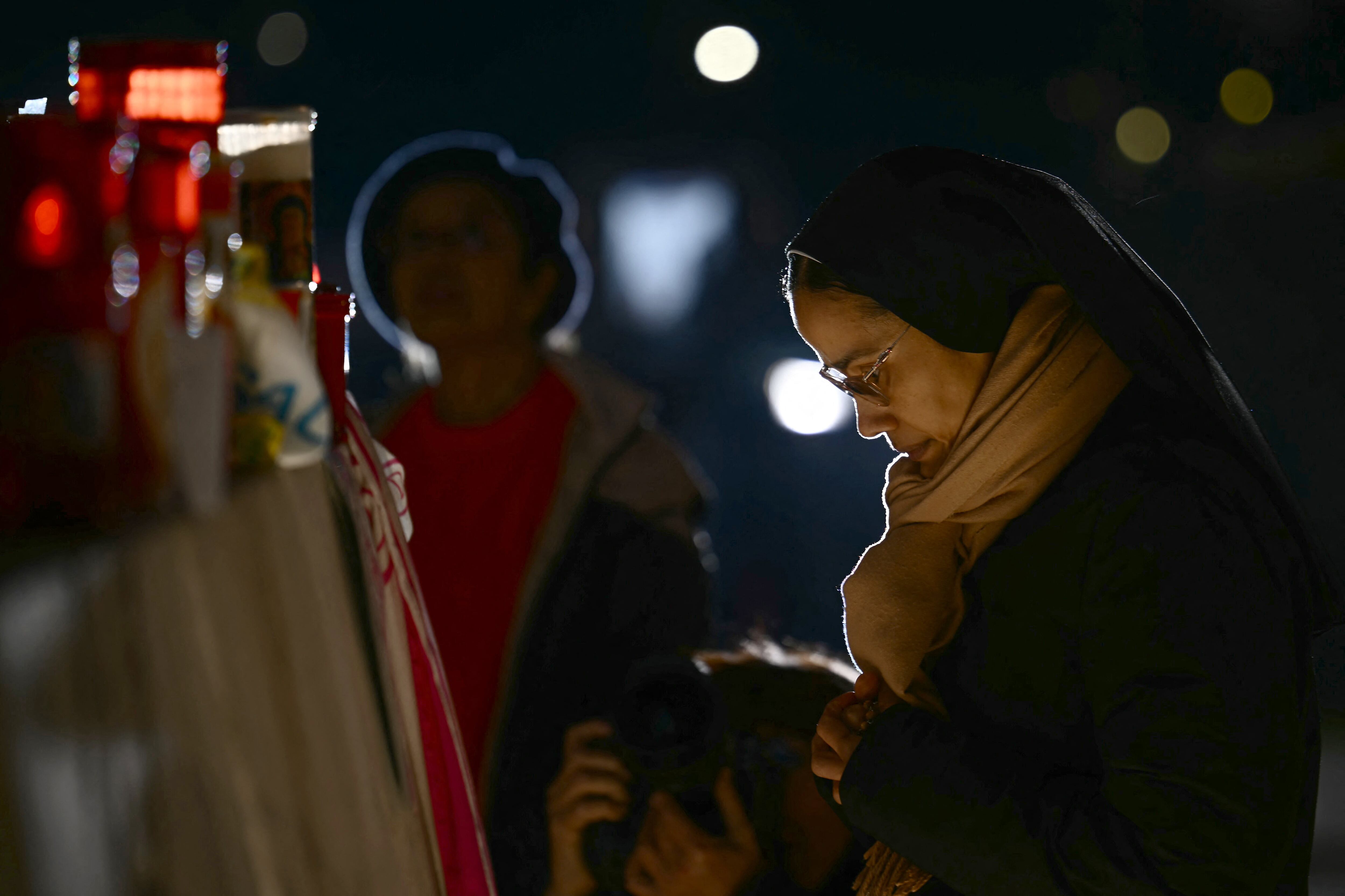 A nun prays at the statue of John Paul II outside the Gemelli University Hospital where Pope Francis is hospitalized with pneumonia, in Rome on March 03, 2025. Pope Francis suffered two new breathing attacks on March 3, 2025, the Vatican said, as the 88-year-old pontiff struggles to recover from pneumonia. "Today, the Holy Father