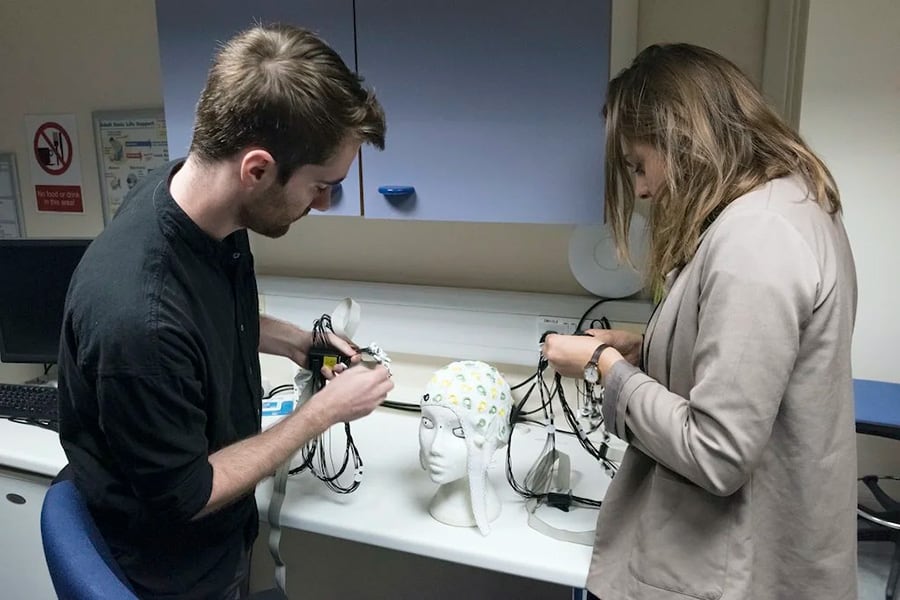 Investigadores del laboratorio de Steve Fleming preparan un gorro para electroencefalograma para realizar experimentos en los que se registra la actividad cerebral mientras los sujetos realizan tareas cognitivas.