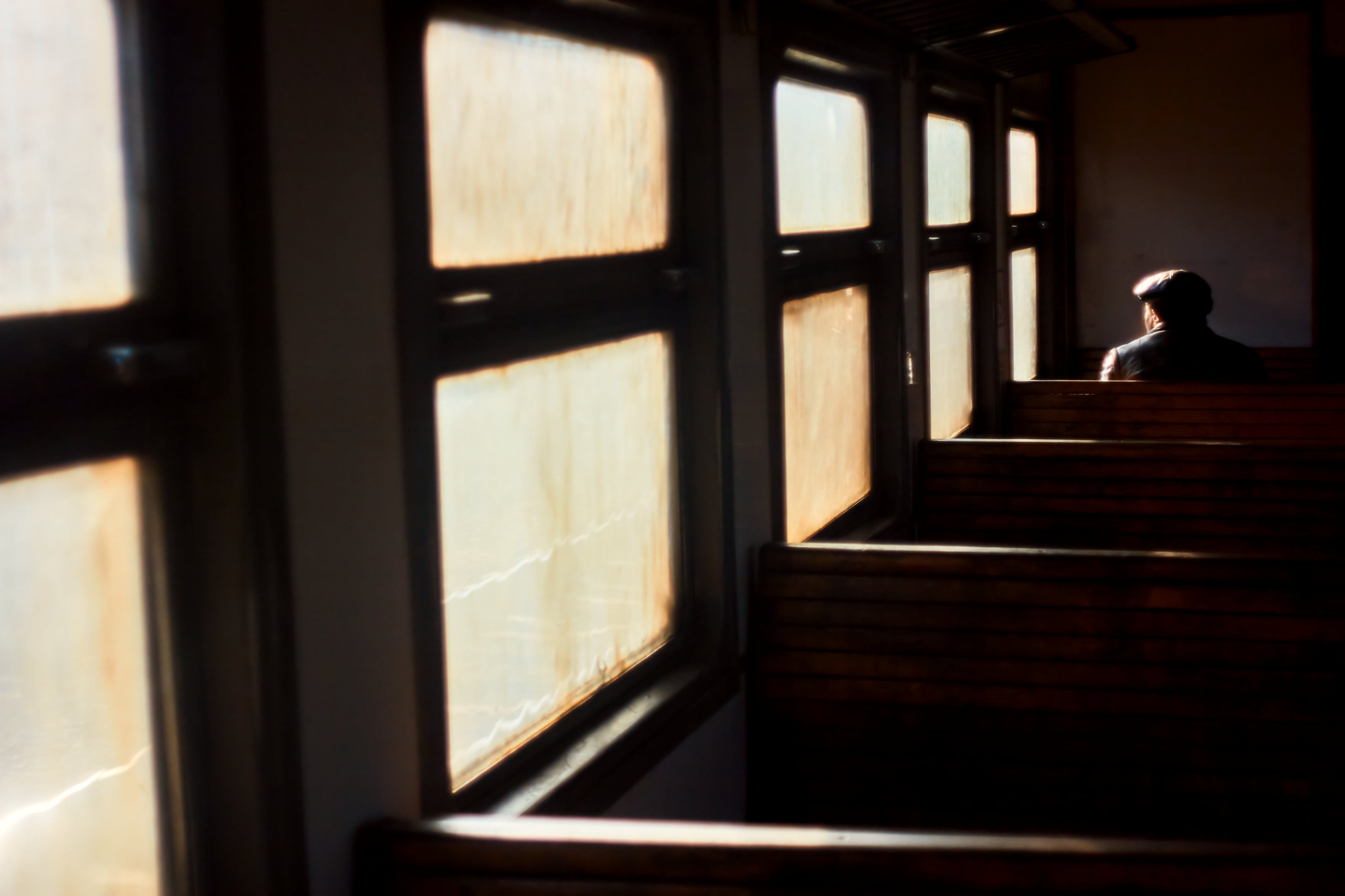 Hombre adulto, pasajero solitario viajando en tren vacío, mirando por la ventana