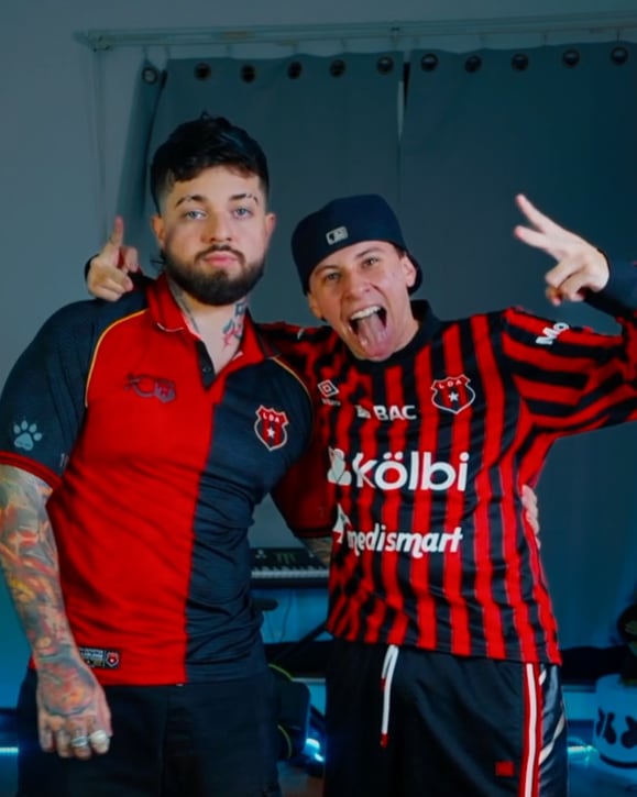 Los creadores de contenido Keiz y Corney llegaron a una apuesta. Corney posa alegre porque su equipo ganó, mientras que Keiz paga el que su club haya perdido.