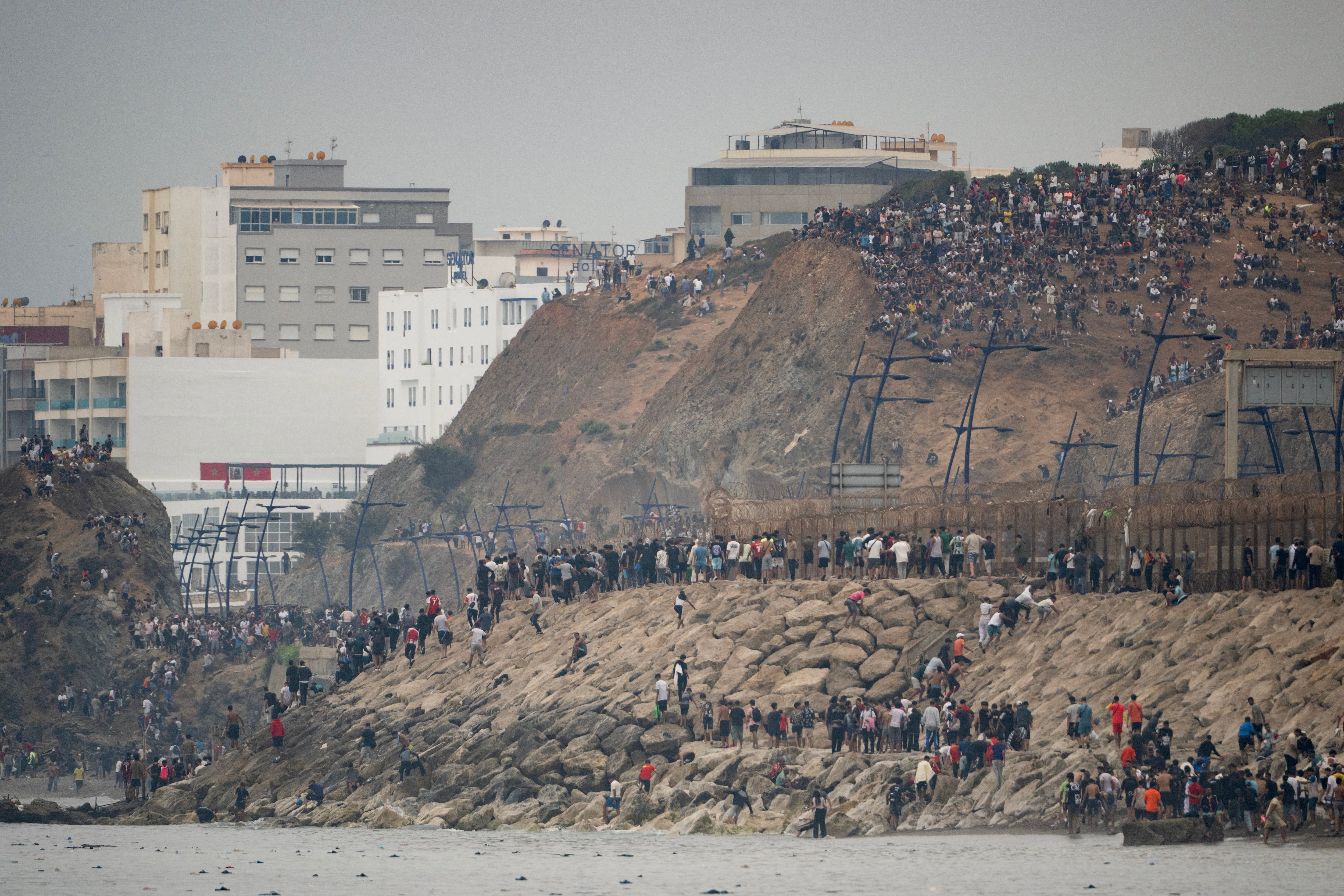 Migrants cross back to Morocco after they crossed the border to enter Spain's north Africa's Ceuta enclave on July 31, 2026. Thousands of migrants crossed overnight from Morocco into Ceuta enclave, a police source said, as Spanish Prime Minister was set to arrive to manage the latest migrant crisis on the border. In recent days, a total of around 40,000 migrants have crossed into the territory, population 80,000, the source added. (Photo by Jorge GUERRERO / AFP)