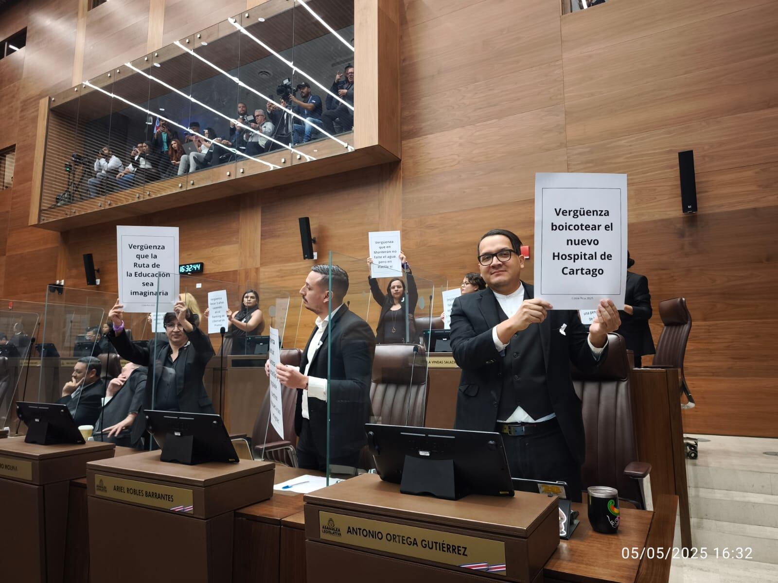 Mientras el presidente Chaves rinde el informe de labores, legisladores de oposición levantron carteles con mensajes de protesta.