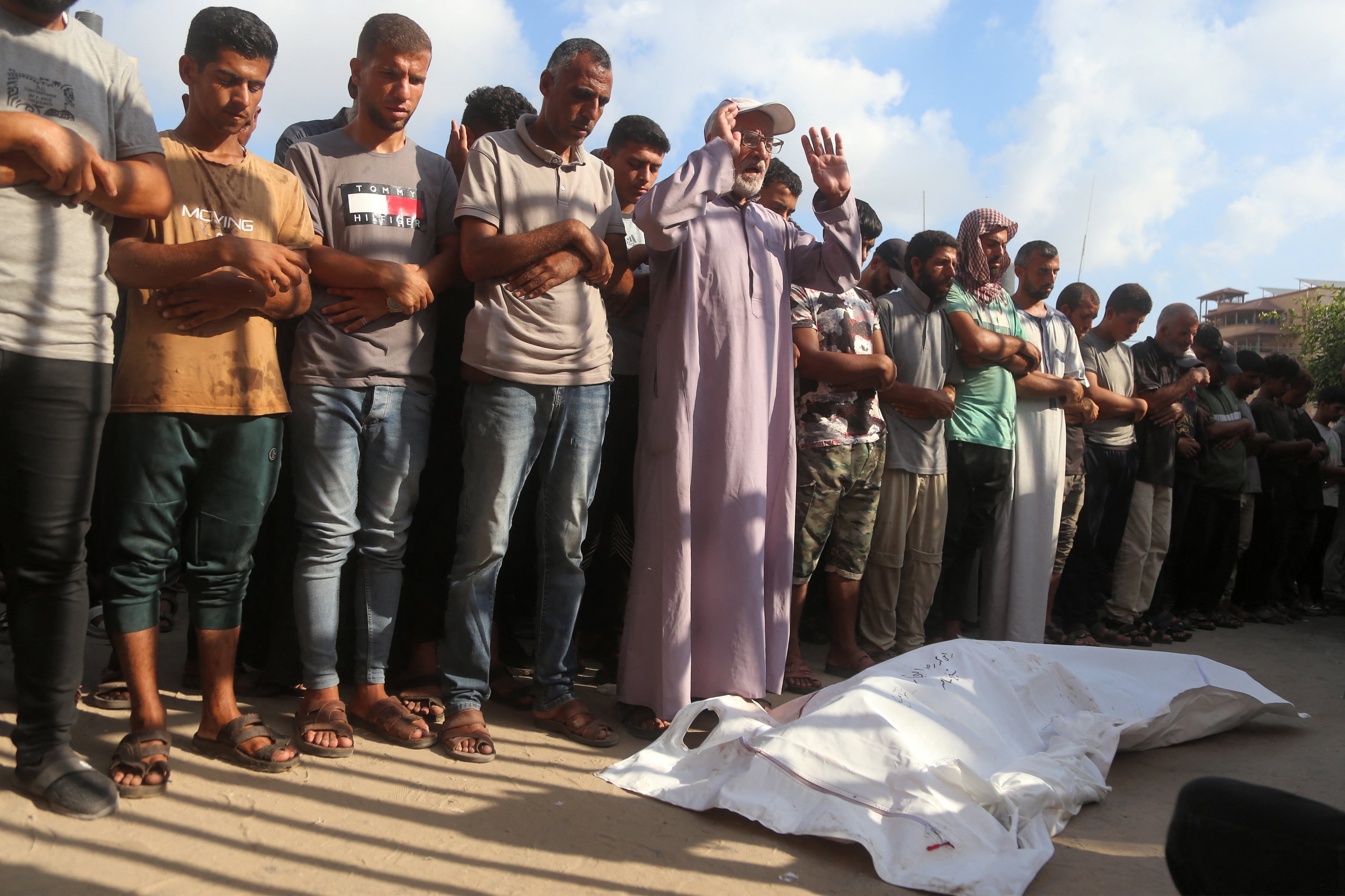 Dolientes junto a los cuerpos de las víctimas que murieron por los bombardeos israelíes, mientras yacen en el exterior durante el funeral en el Complejo Médico Nasser en Khan Yunis, en el sur de la Franja de Gaza, este 20 de julio. Fotografía:
