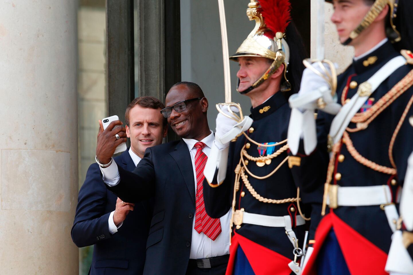 El presidente francés, Emmanuel Macron, se hace un selfie con un miembro de la delegación de Costa de Marfin en el palacio del Elíseo en París.