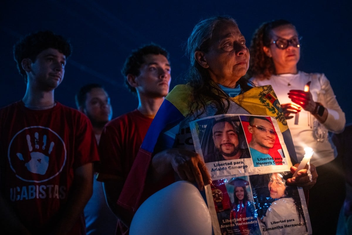 Una mujer muestra un cartel durante una vigilia para exigir la liberación de presos políticos frente a la prisión El Rodeo I, en el estado Miranda, el 2 de marzo de 2026.