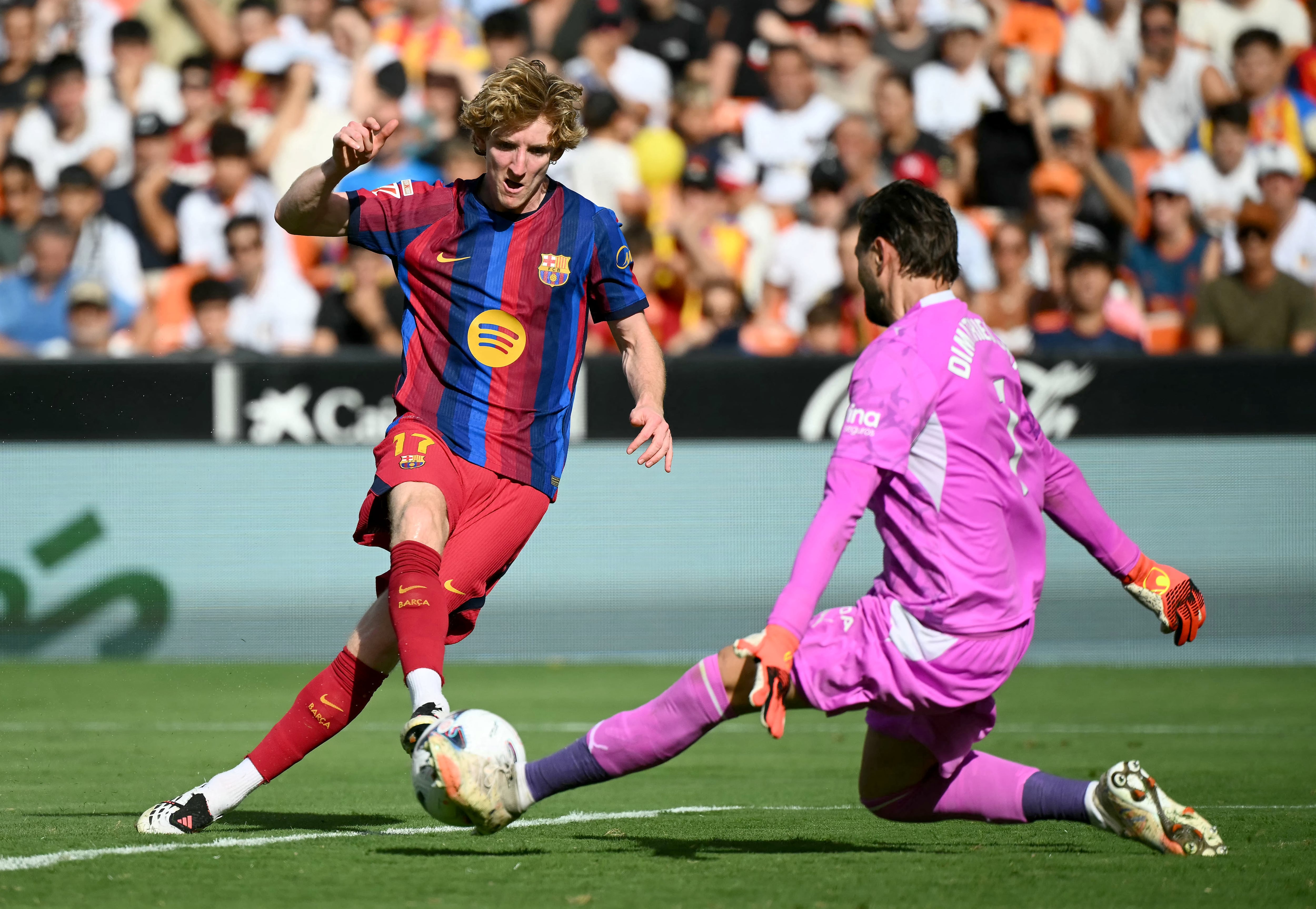 El delantero del Barcelona Anthony Gordon remata ante el arquero del Valencia, Stole Dimitrievski, durante el partido por la Liga Española en el Estadio Mestalla.