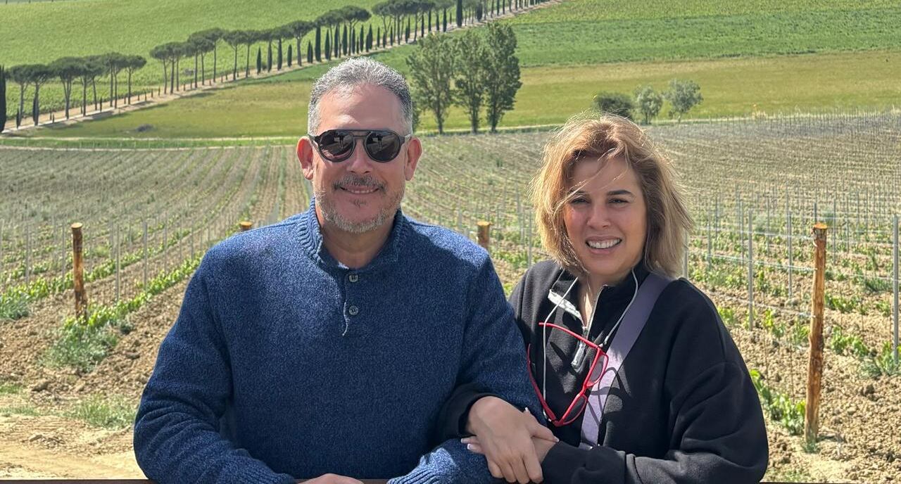Una mujer y un hombre juntos posan frente a la cámara en un ambiente de campo.