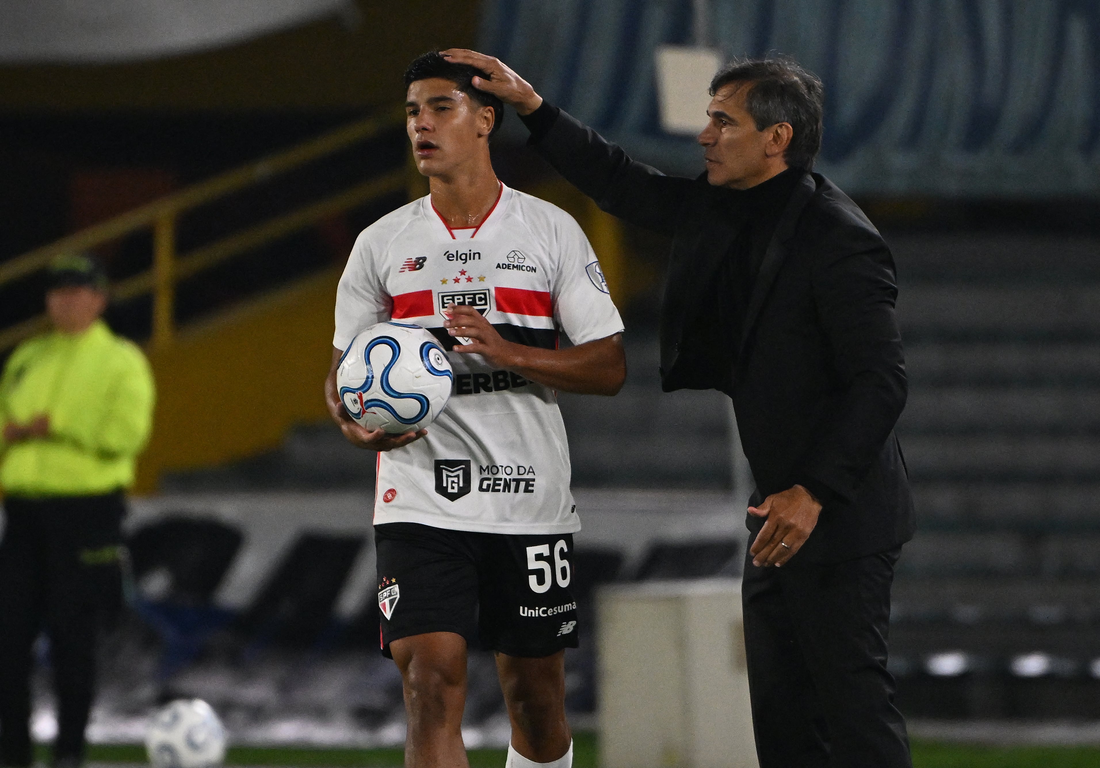 El entrenador de Millonarios de Colombia, Fabián Bustos, toca la cabeza de Nicolas Bosshardt, jugador del Sao Paulo que ahora enfrenta un grave proceso por el atropello de una persona.