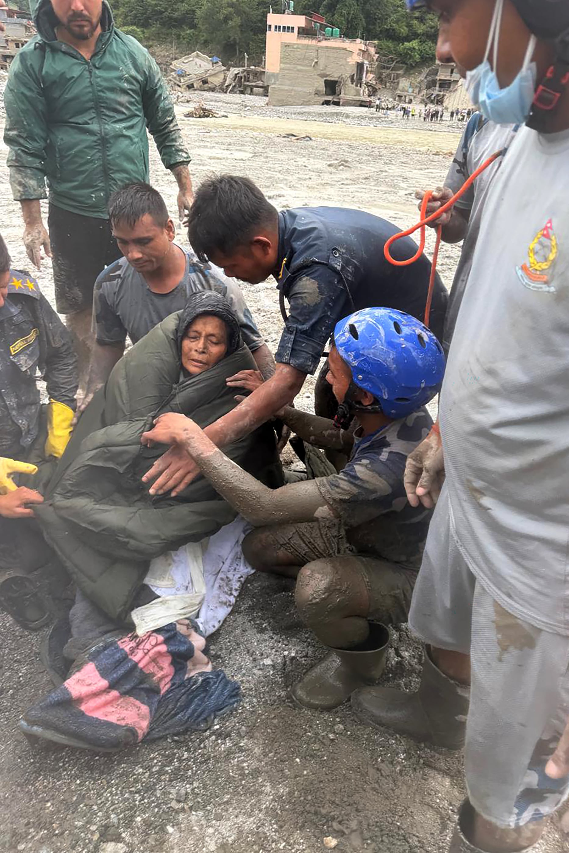 Esta fotografía facilitada y publicada el 5 de septiembre de 2026 por la Fuerza de Policía Armada de Nepal muestra a personal de seguridad ayudando a una mujer rescatada de una vivienda arrasada por una crecida repentina en Betrawati, en el distrito nepalí de Nuwakot. Las devastadoras inundaciones en la frontera entre China y Nepal han causado la muerte de al menos 1.287 personas en Nepal, según informó el 4 de septiembre la autoridad encargada de la gestión de desastres, situándose la cifra de desaparecidos en 5.083.