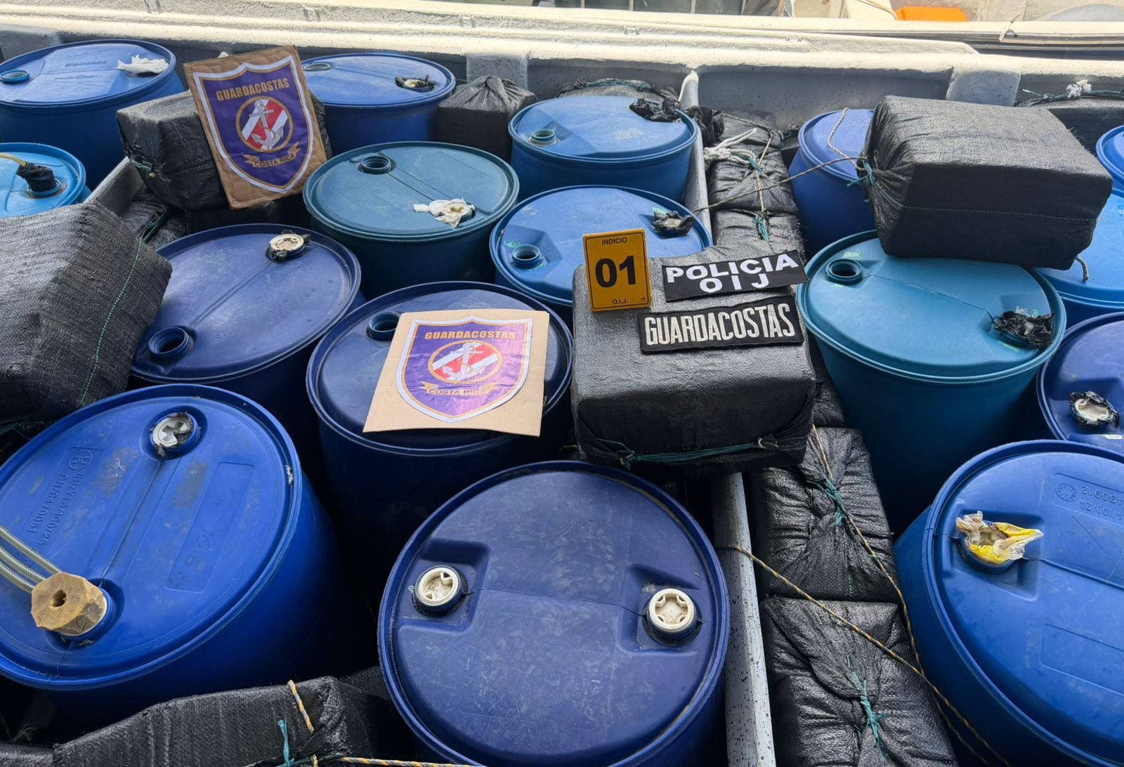 Grandes estañones azules con la droga decomisada este sábado en Golfito, tras la interdicción de una lancha proveniente de Colombia en aguas del Pacífico sur de Costa Rica. El OIJ estimó que el cargamento podría superar la tonelada. [