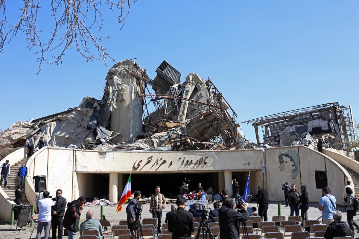 Media representatives gather in front of a heavily damaged building following a strike at the Azadi Sport Complex in Tehran on April 3, 2026. A large explosion shook northern Tehran on April 3, AFP journalists said, with smoke seen rising from the site of the blast, as war with the United States and Israel rages. (Photo by AFP) /