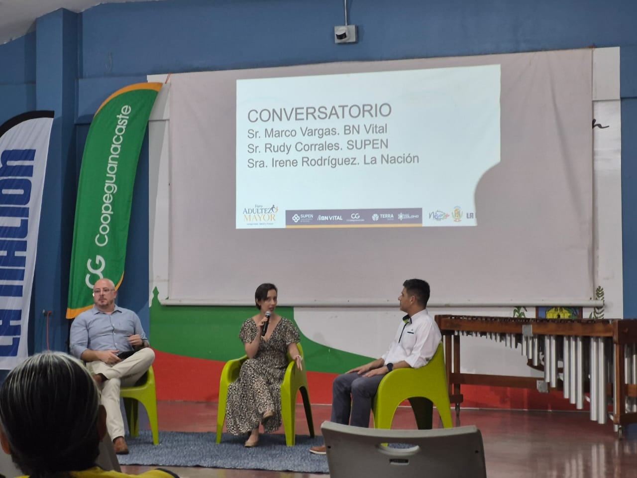 Un conversatorio de tres personas, dos hombres y una mujer al centro.