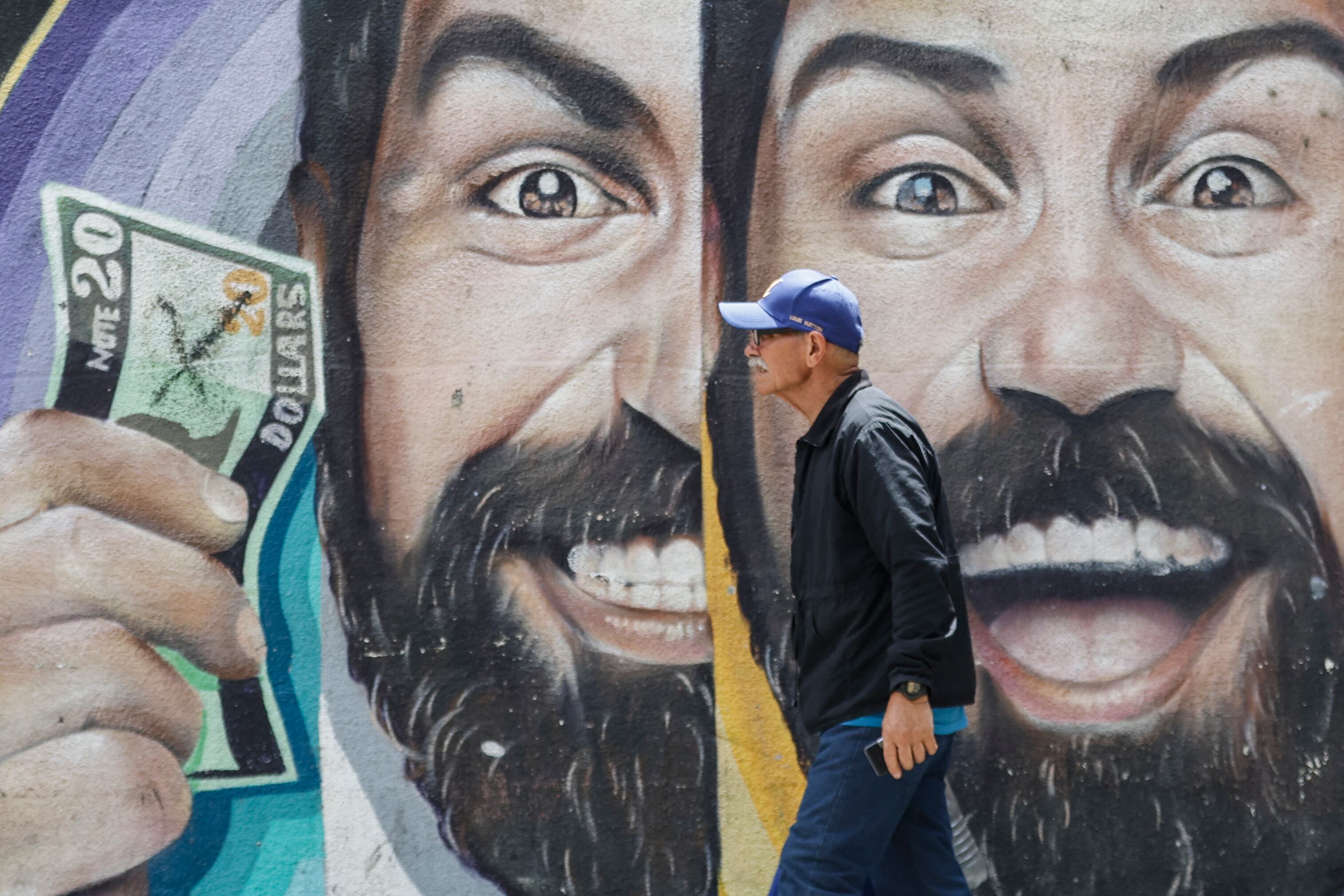Un hombre pasó junto a un mural sobre el tipo de cambio en Caracas, Venezuela, el pasado 2 de junio. Fotografía: