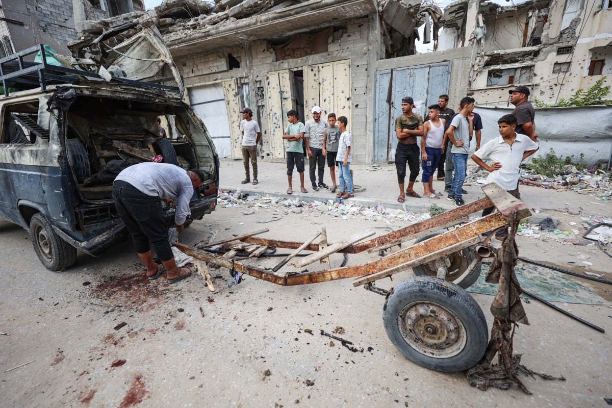 Palestinos inspeccionan los daños tras un ataque aéreo israelí que alcanzó un minibús y mató a cinco personas en el barrio de Tel al-Hawa, en Ciudad de Gaza, el 30 de septiembre de 2026, según la agencia de Defensa Civil de Gaza y un hospital.