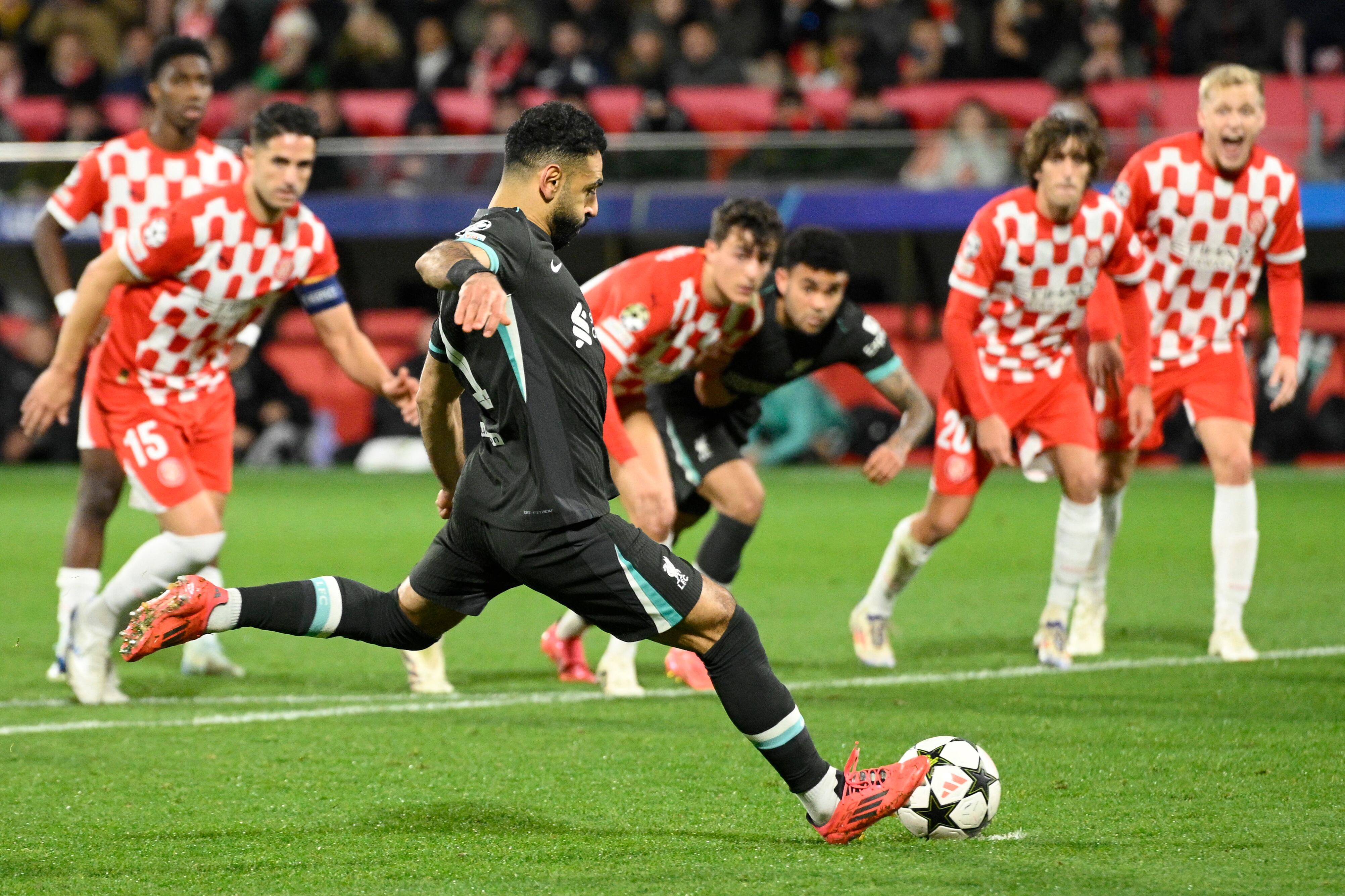 Liverpool's Egyptian forward #11 Mohamed Salah shoots from the penalty spot and scores the opening goal during the UEFA Champions League, league phase football match between Girona FC and Liverpool FC at the Montilivi stadium in Girona on December 10, 2024. (Photo by Josep LAGO / AFP)